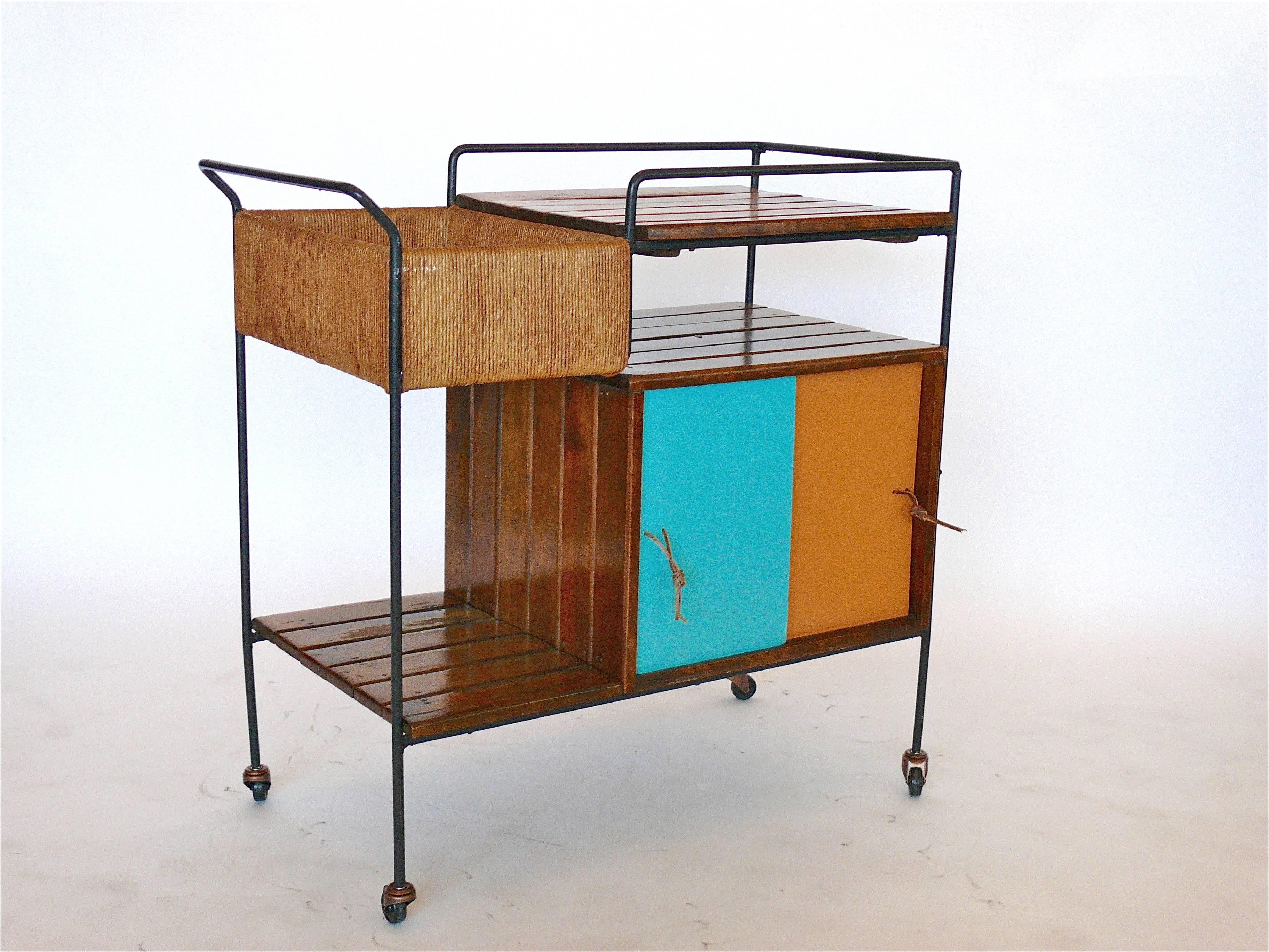 Great bar cart by Arthur Umanoff for Raymor. Black wrought iron frame, wood slat shelving, woven rushed storage compartment and sliding lacquered doors with extra storage. Doors in great original colors. Great original vintage condition with