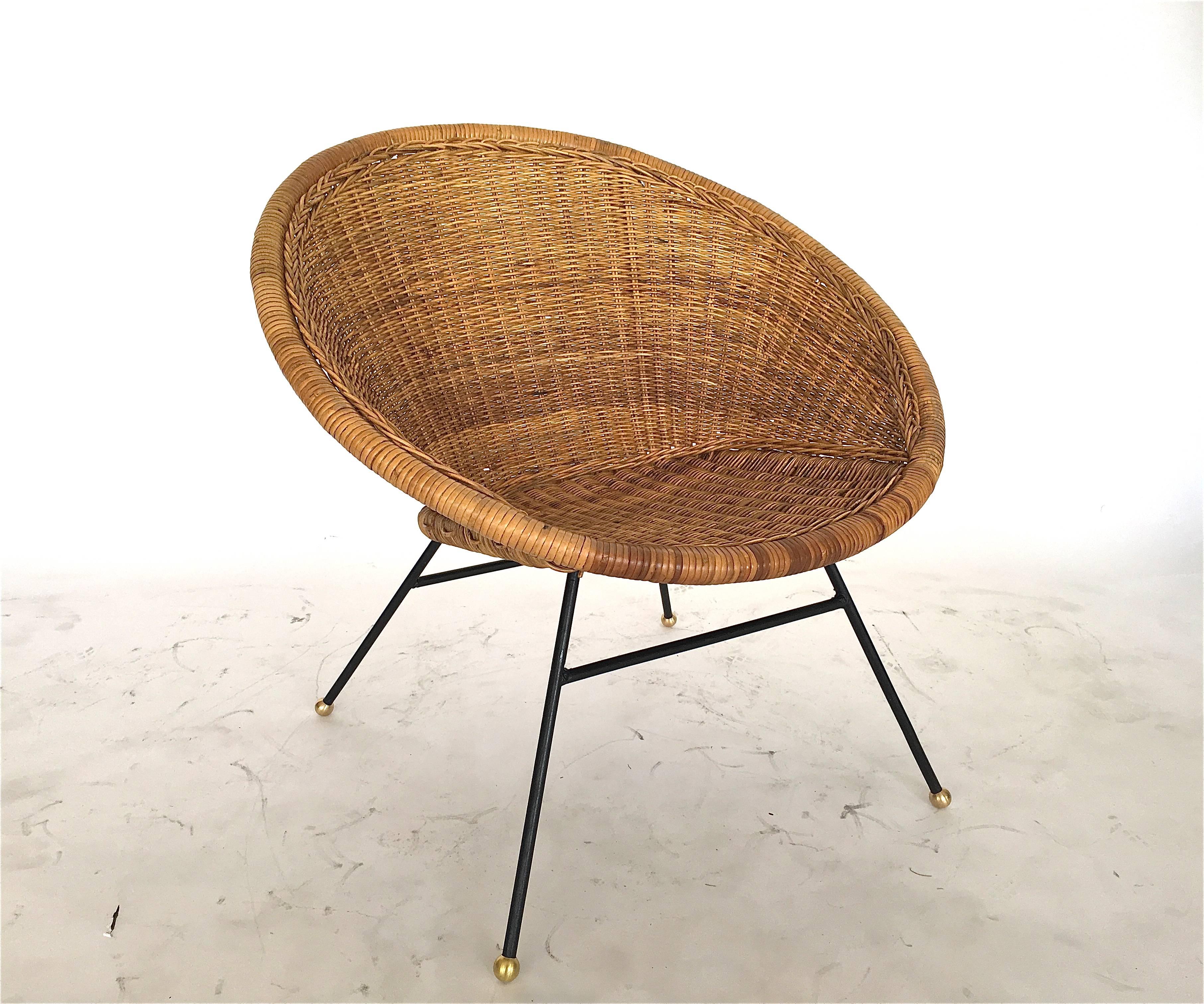Wonderful wicker and iron bucket chair. Wicker in excellent condition. Scooped wicker seat sits on solid iron legs with brass ball feet. Perfect for the home or covered outdoor patio. Only one chair available in this style.
Similar styles available.