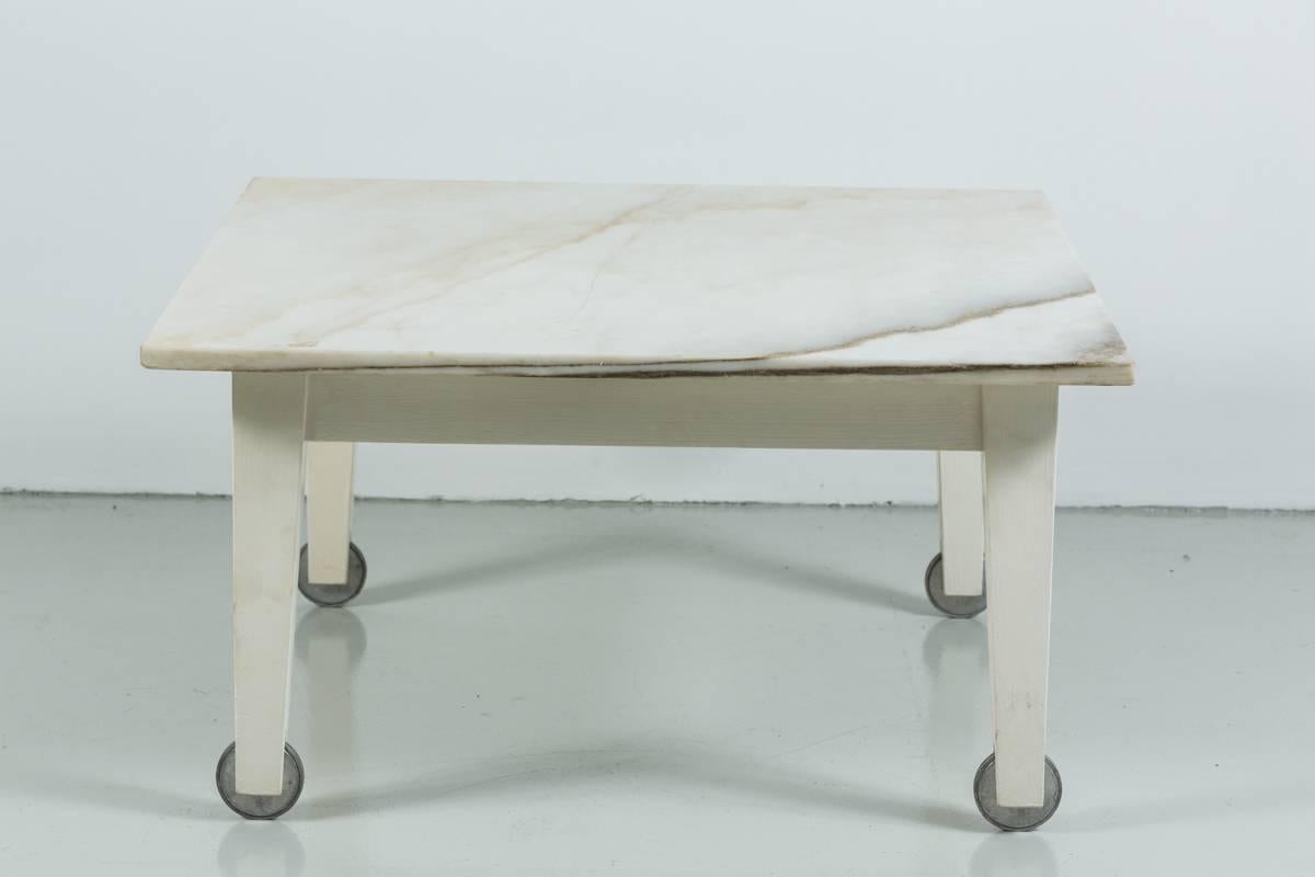 Great original Philippe Starck coffee table designed for the Delano Hotel in Miami. Beautiful marble on tapered white wood legs and grey counter sunk casters.
Small crack in marble.