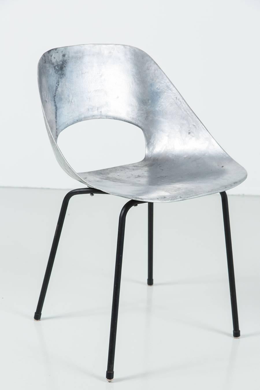 Incredible cast aluminum chairs by Pierre Guariche. Sculpted and curved aluminum seat with cut-out sits on sleek four leg black metal base. 8 available and priced individually.