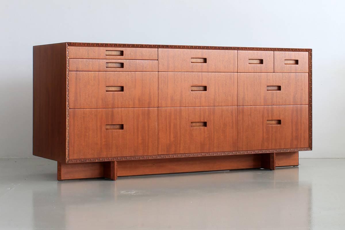 Beautiful dresser by Frank Lloyd Wright manufactured by Heritage Henredon. Distinct carvings from the Taliesin line which was named after Frank Lloyd Wright's home in Spring Green, Wisconsin. Signed by FLW and beautiful refinished. Matching tallboy