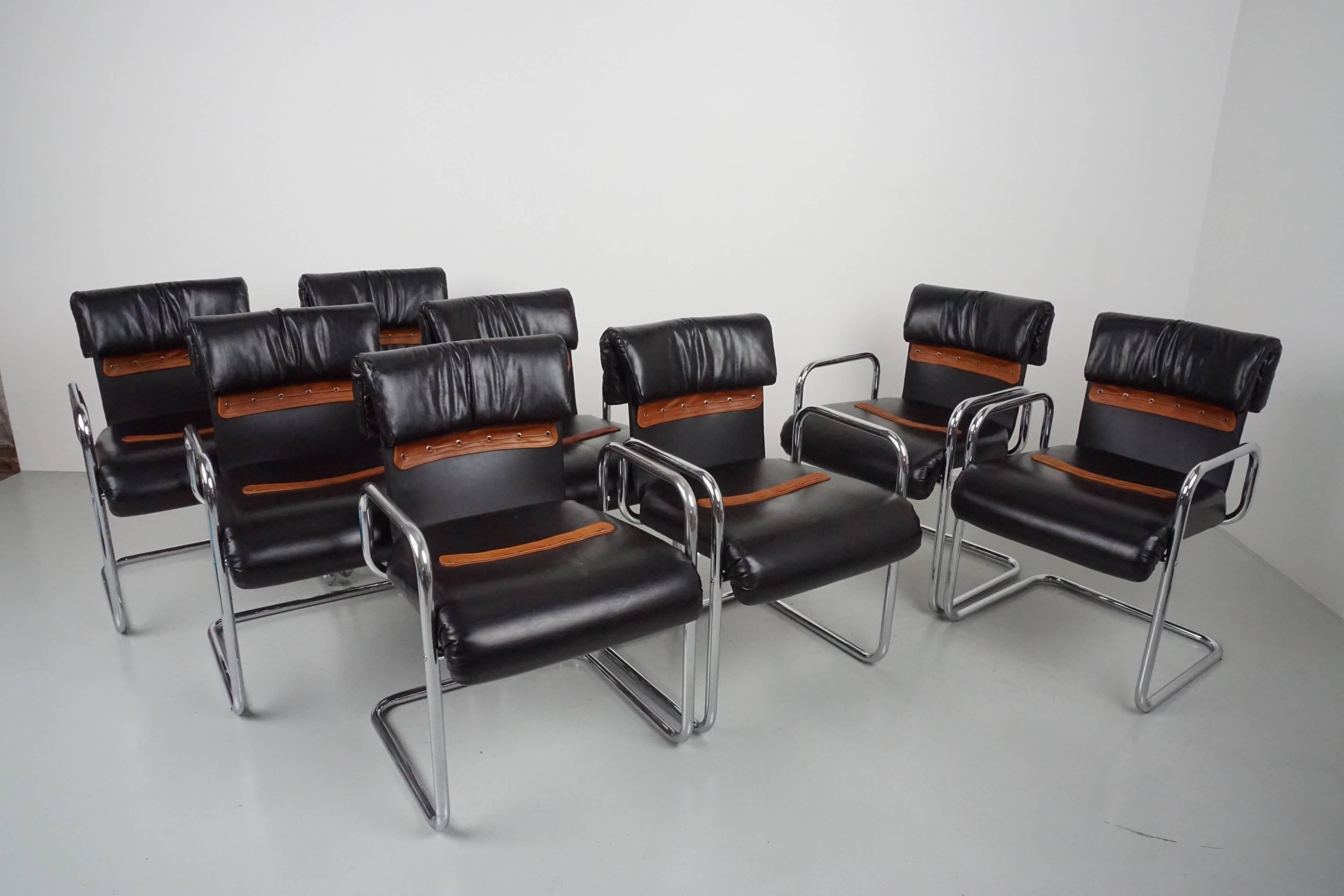 Handsome dining armchairs by Mariani for Pace with cantilevered tubular chrome frame and newly upholstered black leather seats. Fantastic caramel leather detail on seat and back. 
Set of 8 available. 