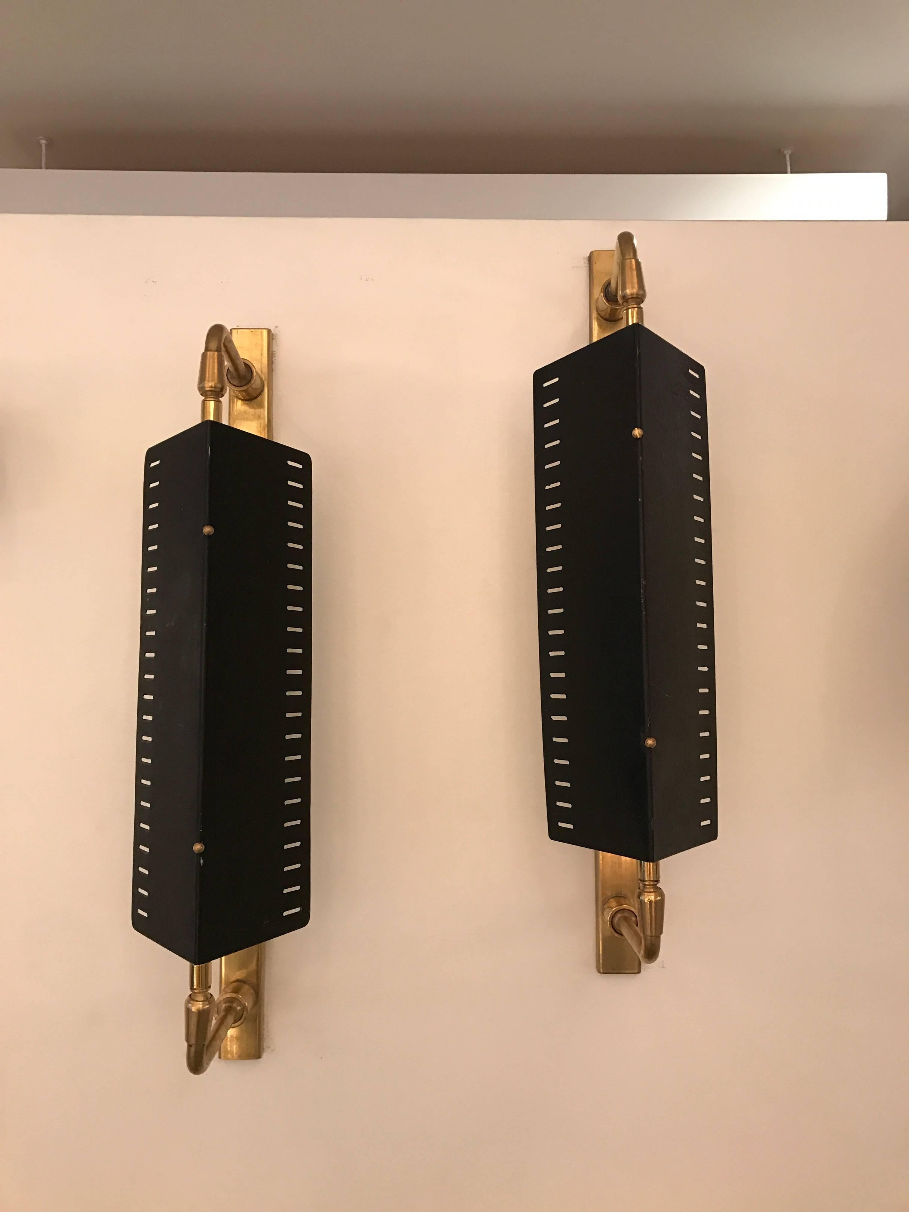 Handsome brass Italian sconces with black metal perforated shade by G.C.M.E. Shade articulates and gives off beautiful light. 
