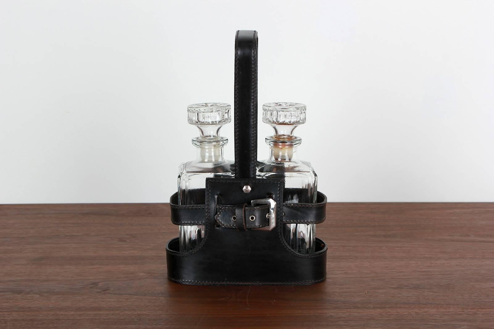 Handsome Adnet style Mid-Century leather caddy. Two impressive decanters with thick glass. Excellent vintage condition.