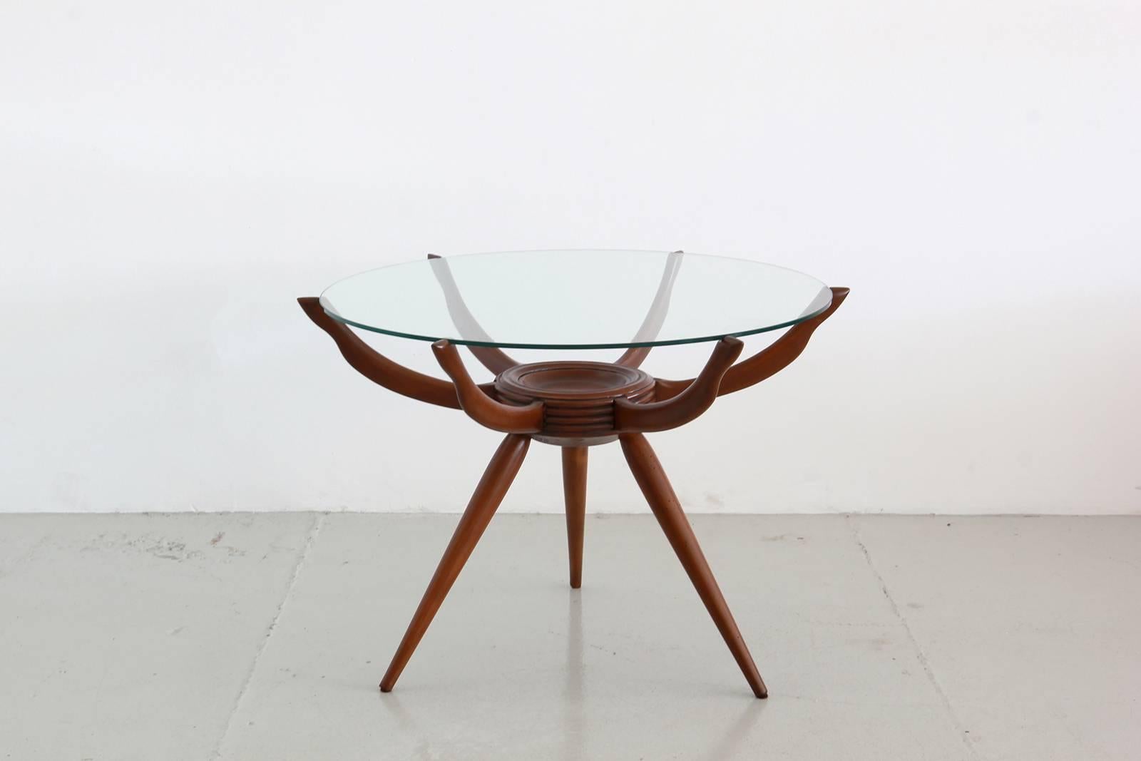 Wonderful Italian spider table by Carlo de Carli with floating glass, tripod legs, and six floating arms supporting original glass.

Refinished Mahogany.