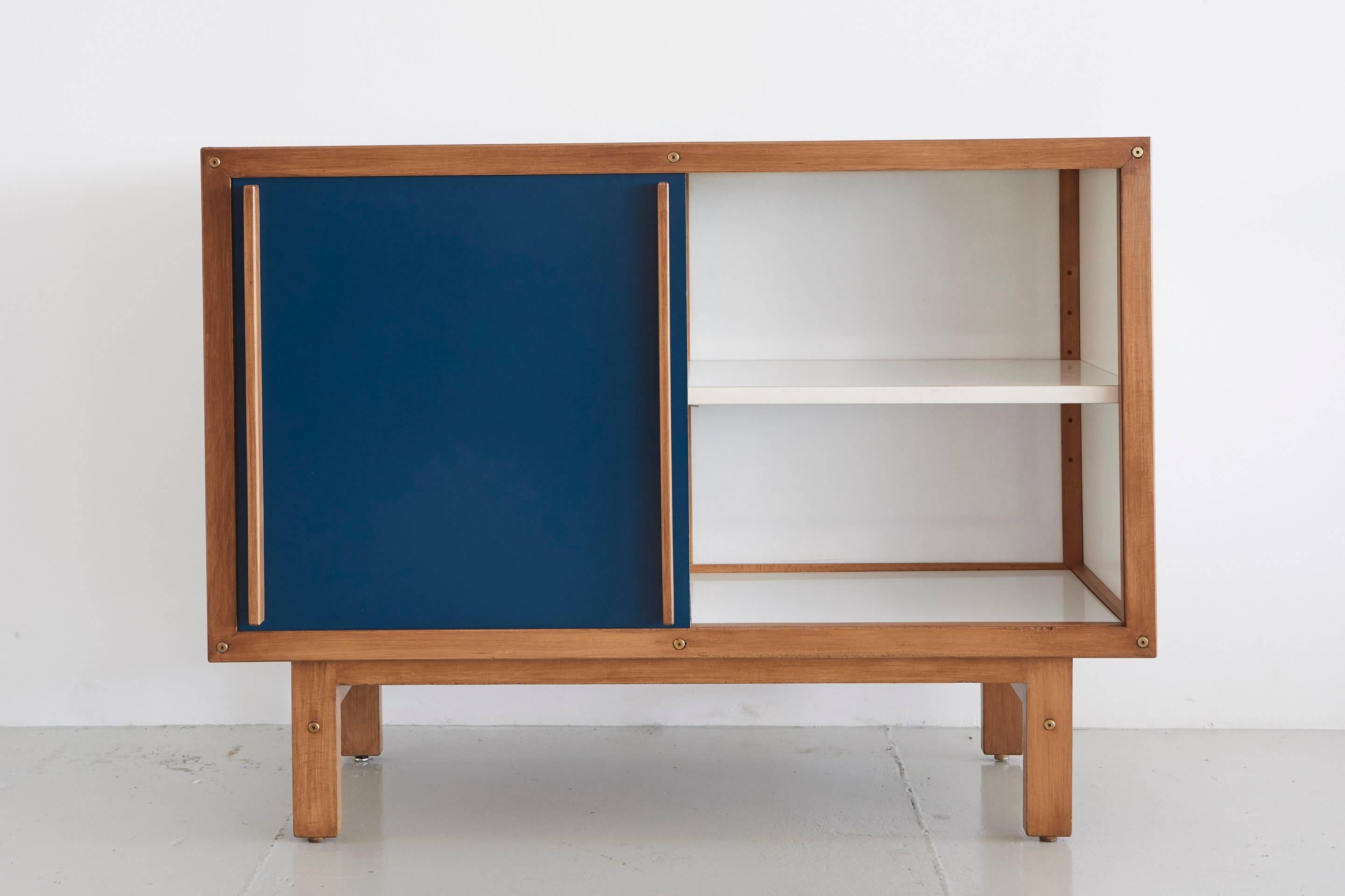 Andre Sornay sideboard with white drawers on one side and open shelving on the other with blue sliding door.
  