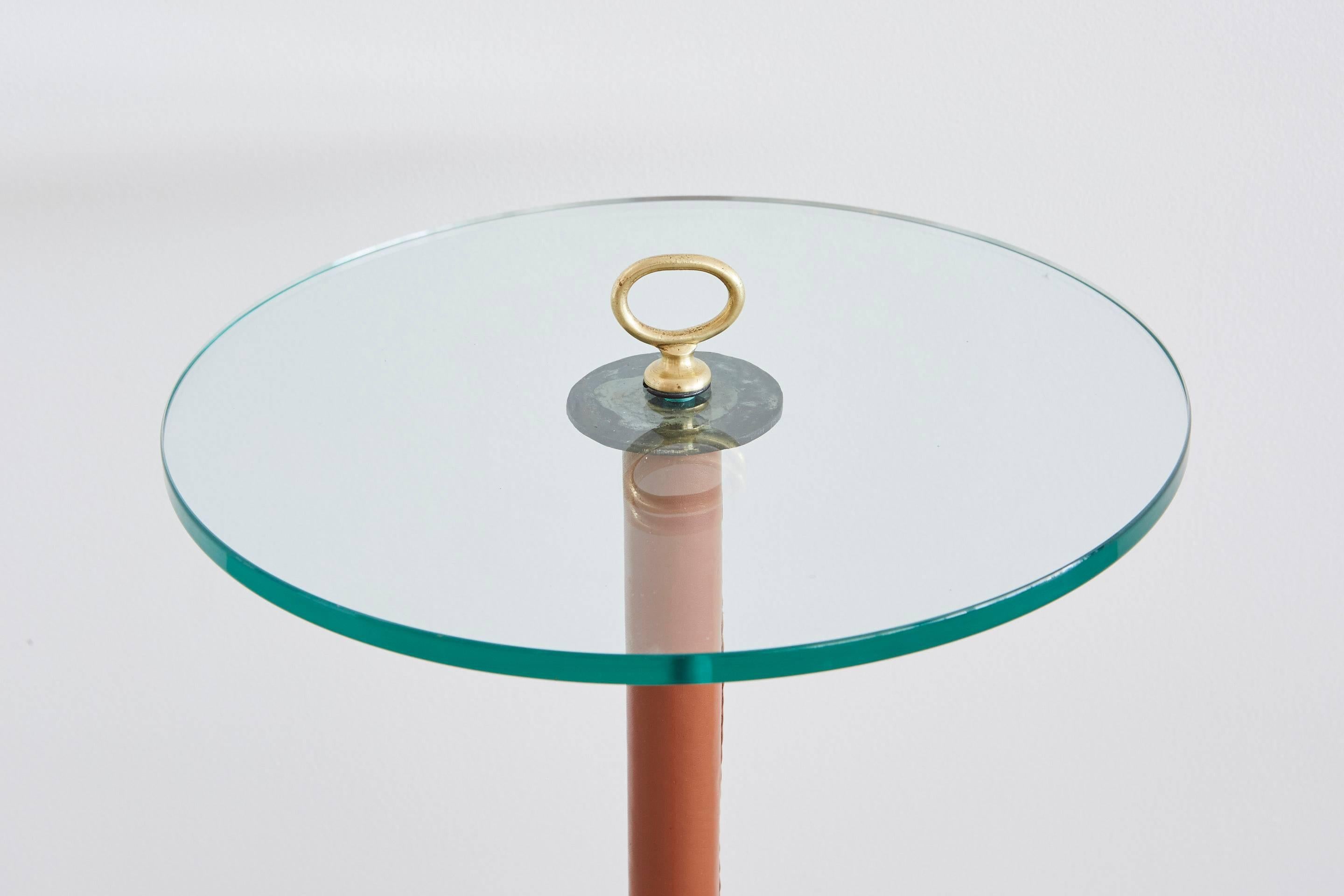 Petite side table by Jacques Adnet in saddle leather with brass ring and new glass.
Could also be used with original brass ashtray stand.