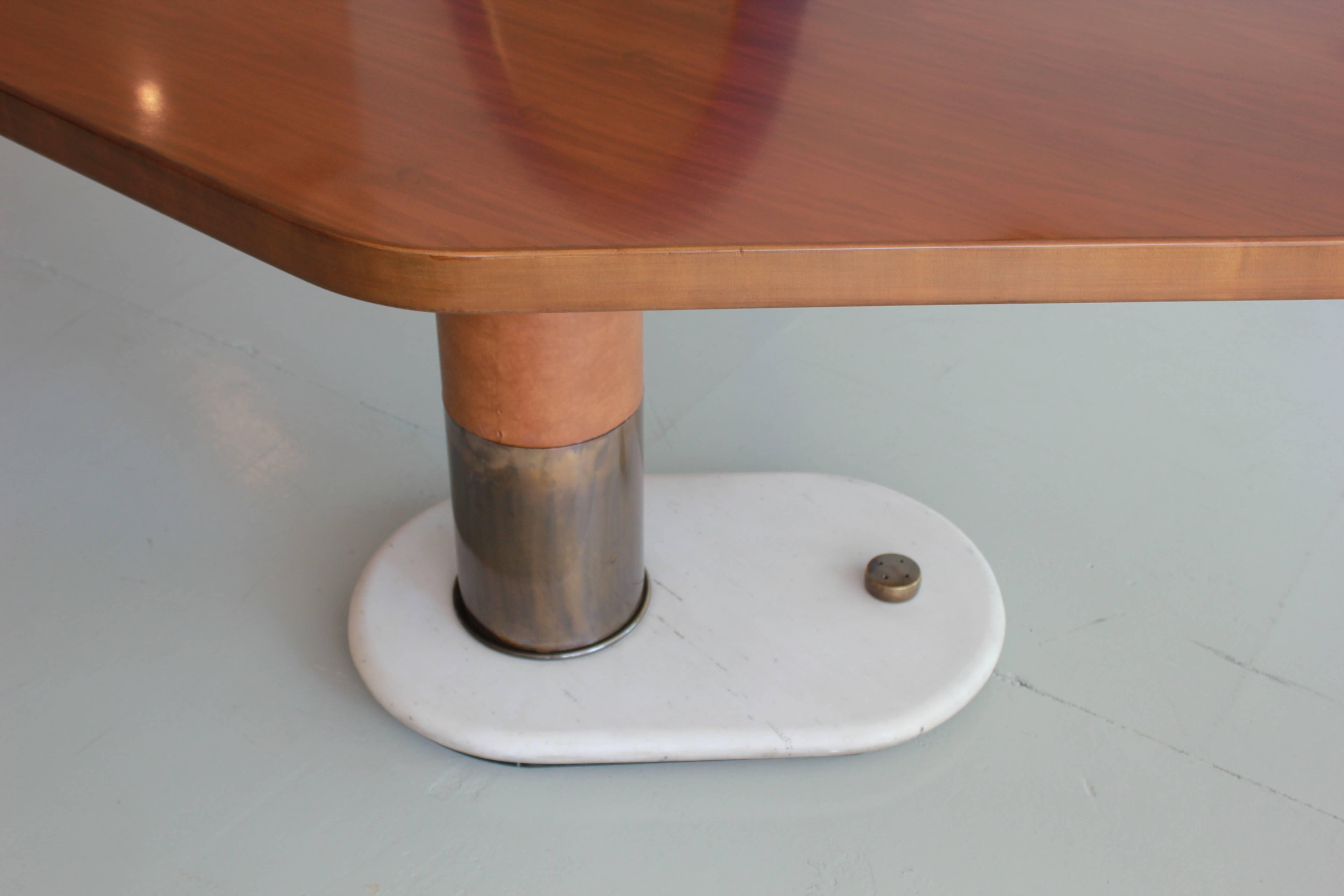 An incredible Italian desk attributed to Gio Ponti with an asymmetrical walnut top over an off-centered cylindrical bronze pedestal wrapped in caramel colored leather. 
Solid marble base has bronze trim. 
Massive in scale and truly unique piece.