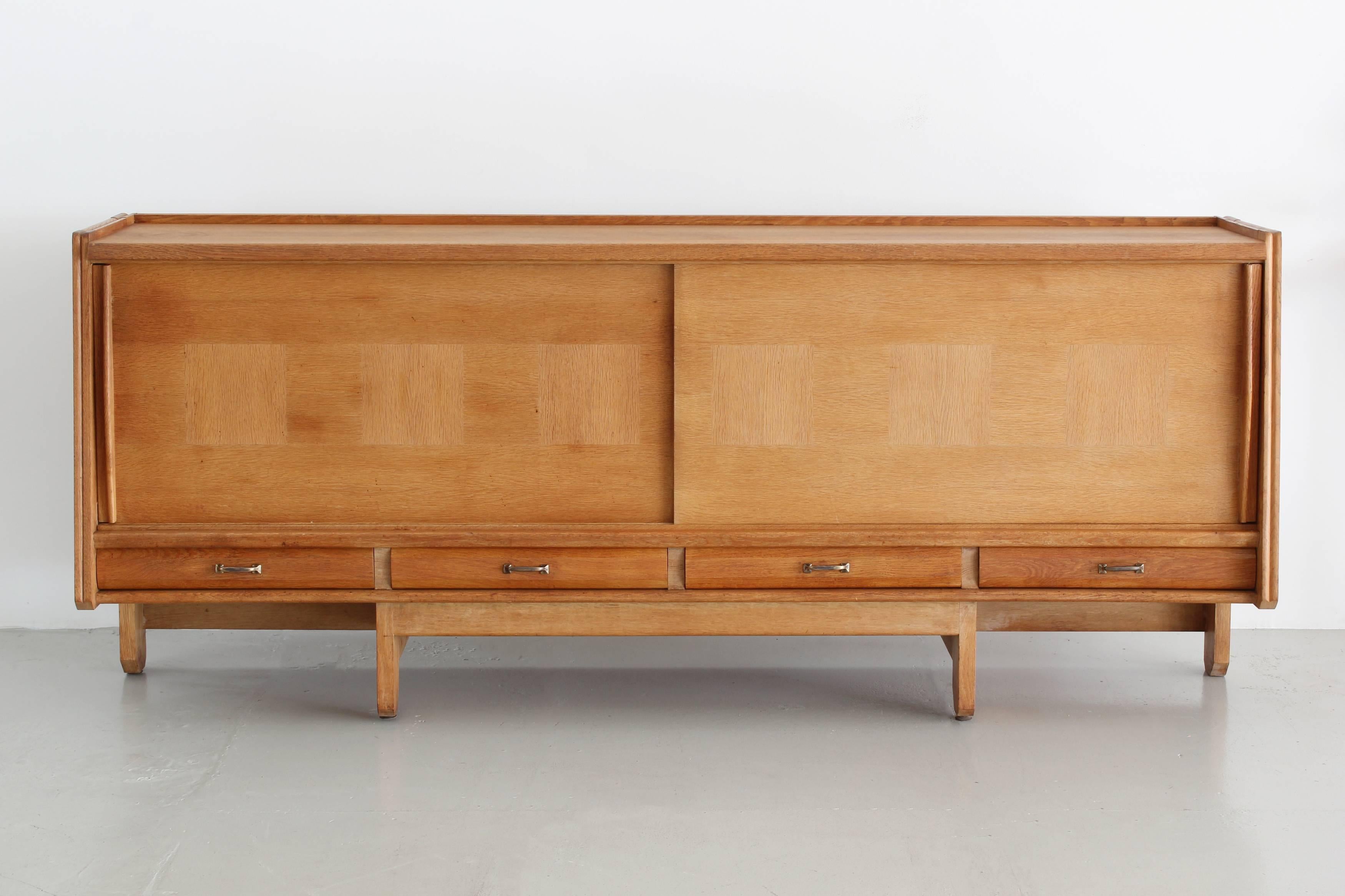 Large sliding door buffet by Robert Guillerme (1913-1990) and Jacques Chambron (1914-2001) with four low pull-out drawers, circa 1950.

Front doors have repeating cross-grain square decoration.