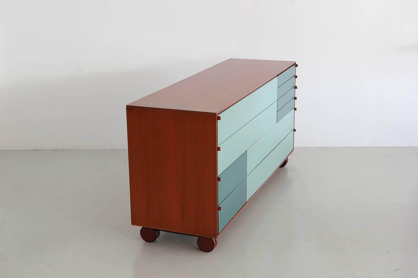 Walnut wrapped chest of drawers by B&B Italia. Drawers are geometric patterns of green-blues with leather tab pulls. Piece is an incredible find and a versatile piece.