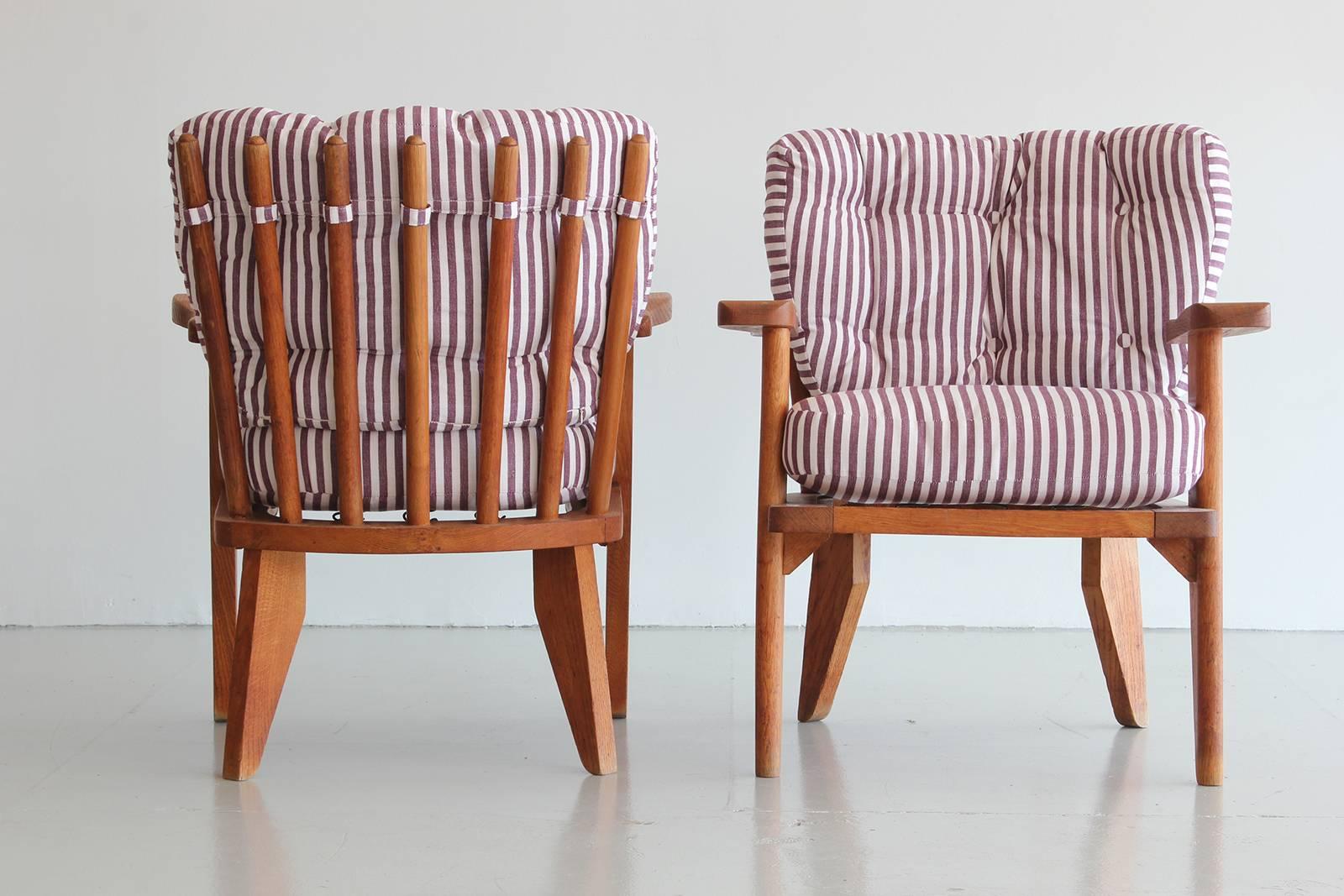 Guillerme & Chambron pair of chairs in oak with floating arms and spindle backs.