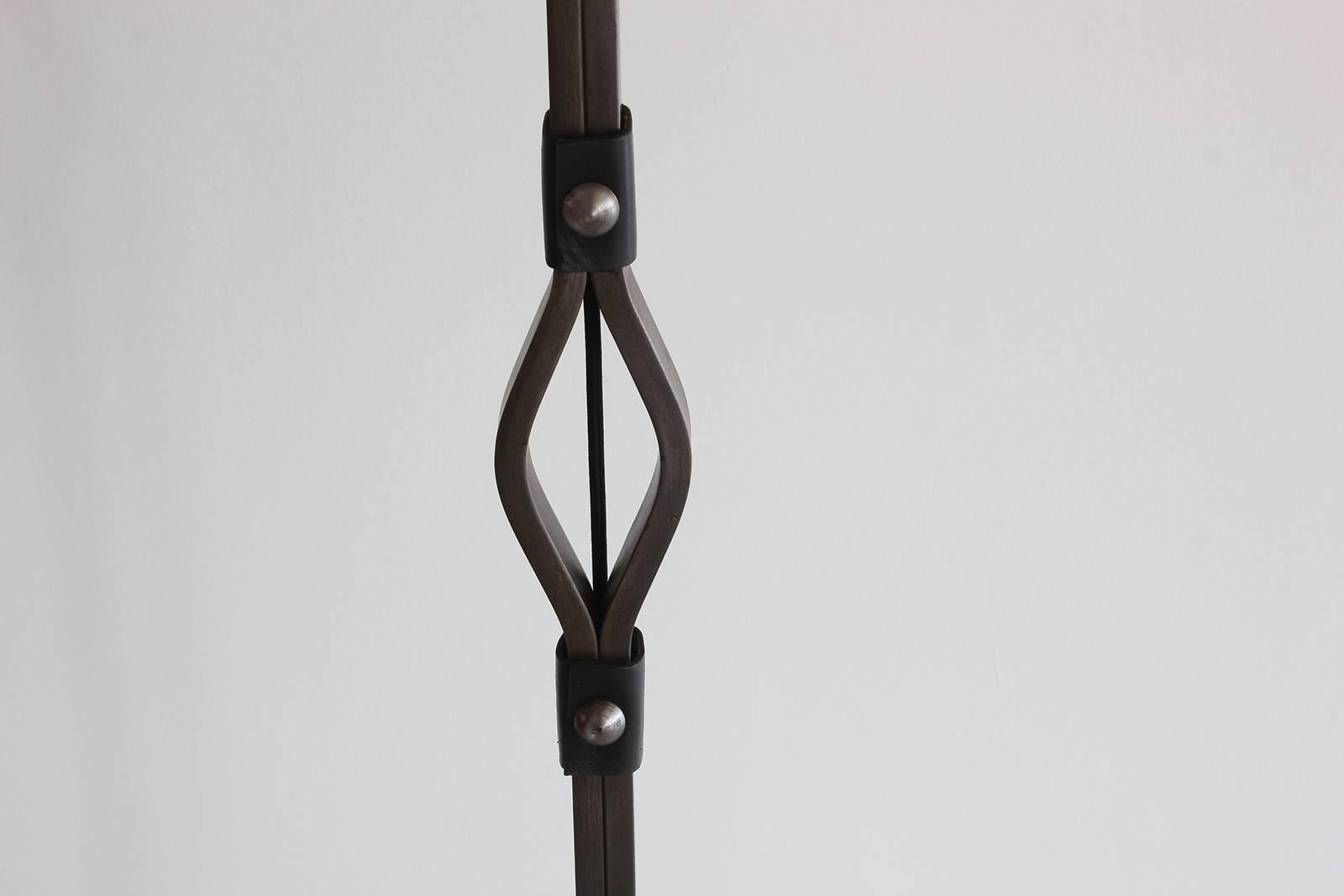 Fantastic iron and leather floor lamp by Jacques Adnet. Horseshoe shaped iron base with new saddle leather detailing throughout. Great patina to original materials. Newly rewired with new linen shade.