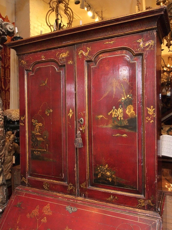 18th century English George III Secretary Bookcase with molded paneled doors over slant front and four drawers.  Red Chinoiserie Decoration with gilt accents is a later addition on the case. Probably from the late 19th century.