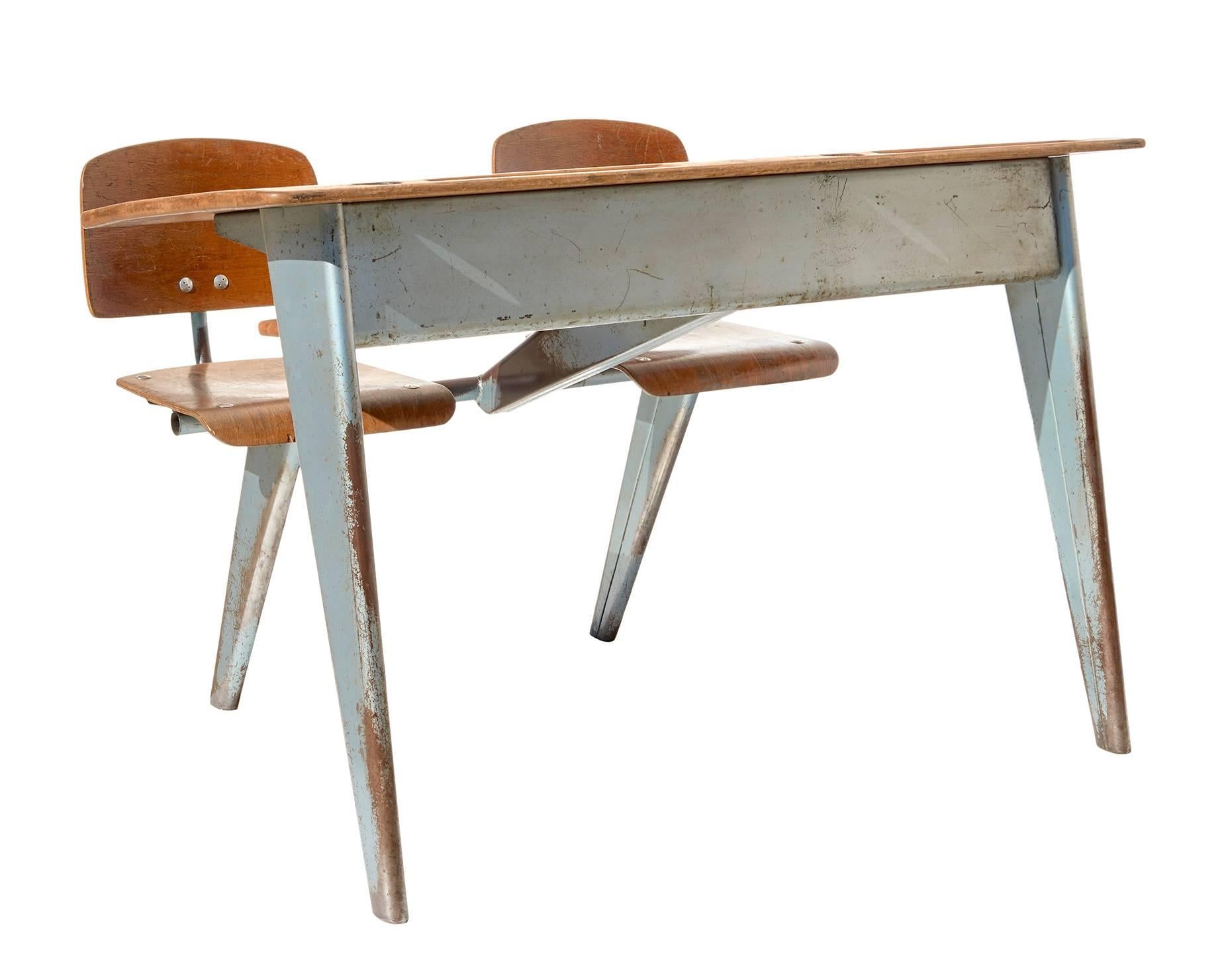 Designed by Jean Prouvé in 1946, and made by his atelier for a few years thereafter, this futuristic-yet-ancient-looking desk for two is in completely original condition, with a gorgeous patina produced by seven decades of French schoolchildren