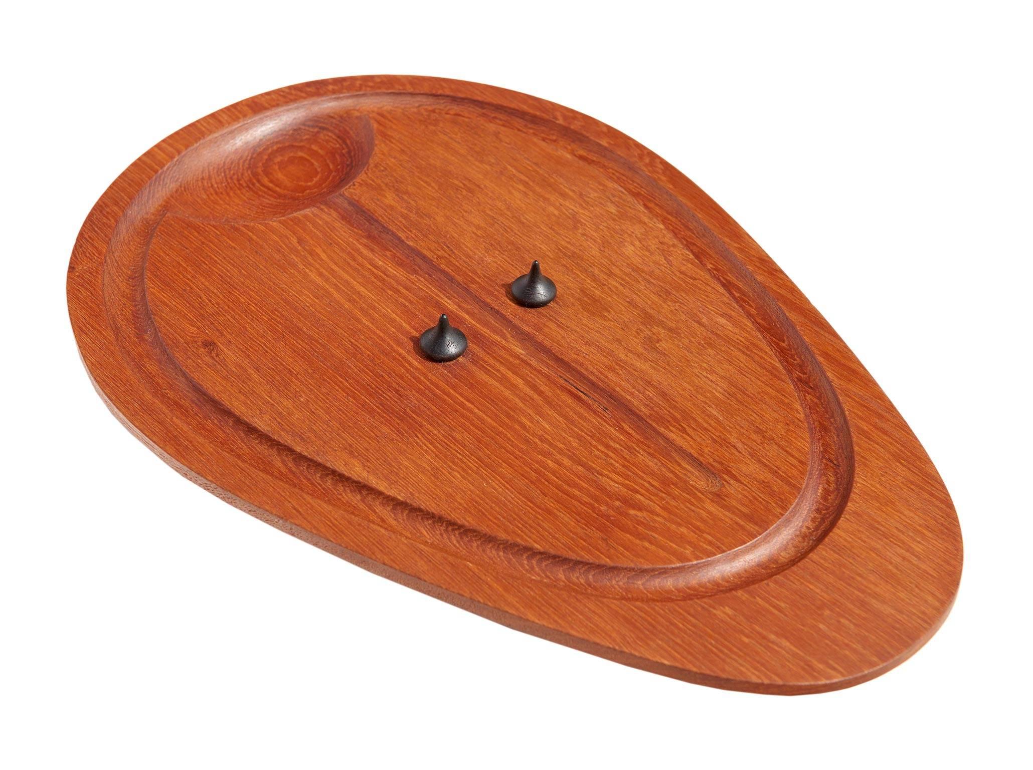The great Danish artisan's anthropomorphic take on a simple board for carving beef is both playful and practical, delightfully resembling a stylized-abstract Primitive mask. The two Brazil rosewood tines (intended to hold the meat in place while