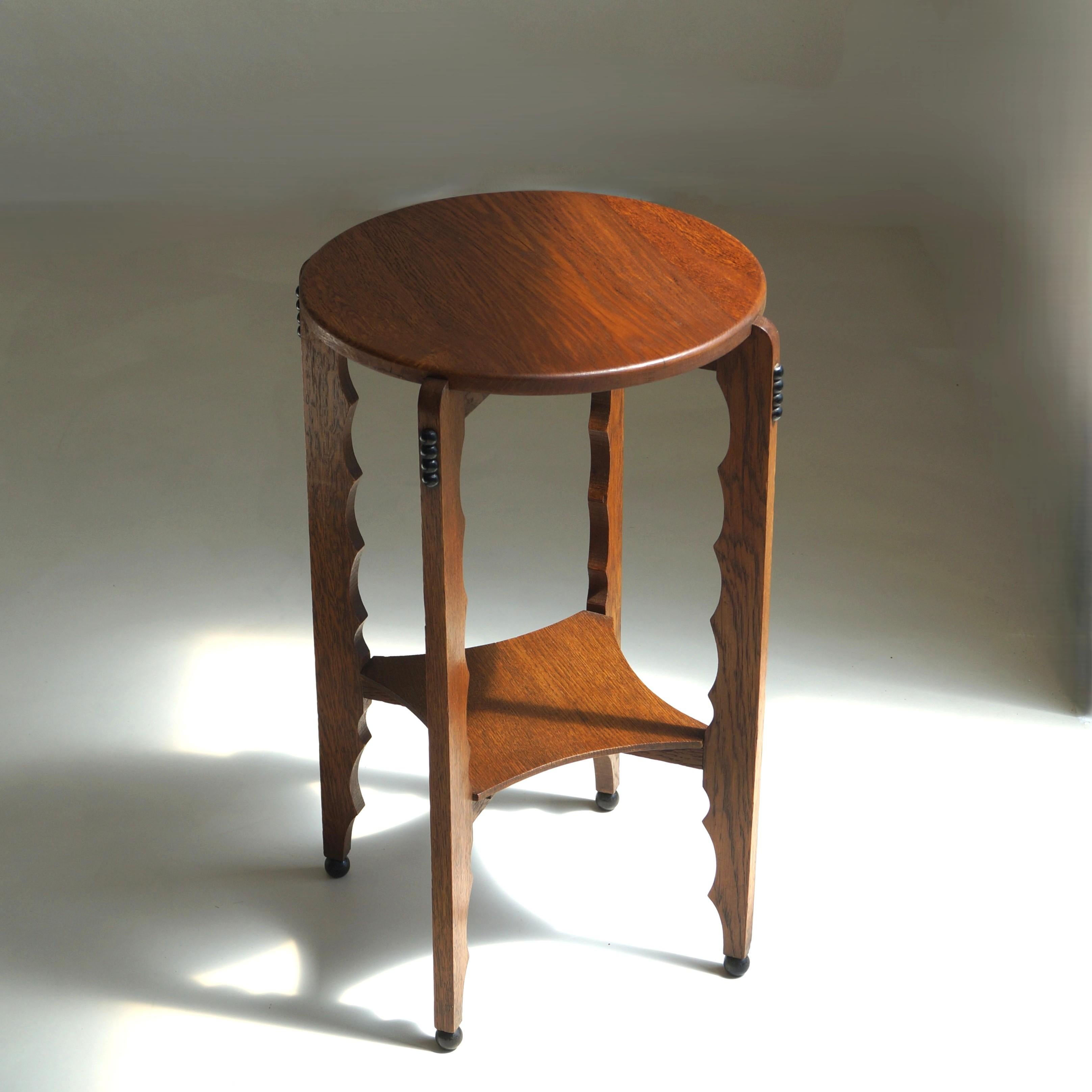 Guéridon de l'école d'Amsterdam au design sculptural, en chêne doux et détails teintés en noir. Sculpture de bois festonnée à l'intérieur des pieds de la table, ce qui donne à la table une belle silhouette. La table attire l'attention en elle-même,
