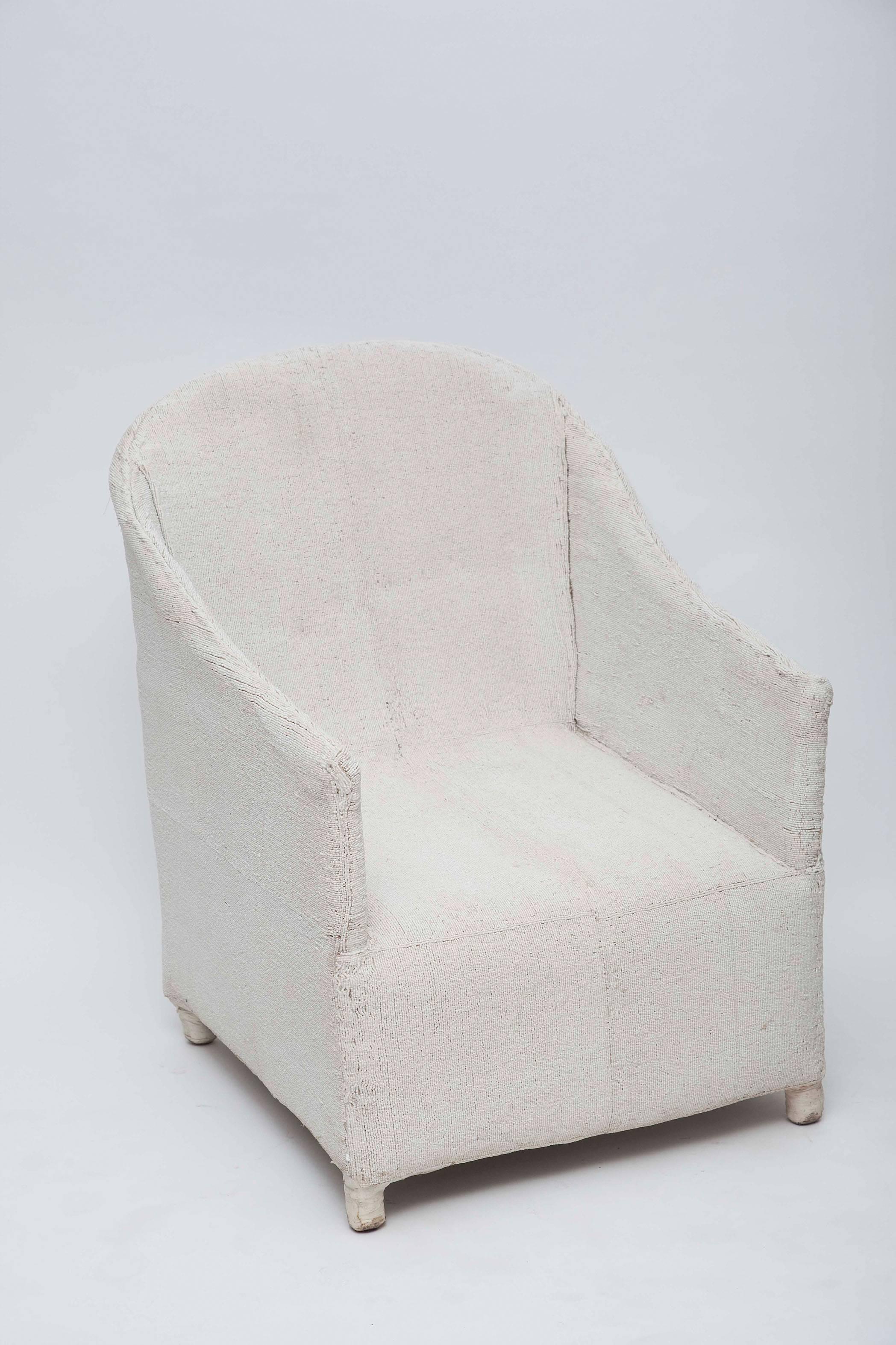 Meticulously assembled by hand in Nigeria using tiny white glass beads over a canvas and wood frame. Each chair is one-of-a-kind and exceptionally unique (and comfortable too)!