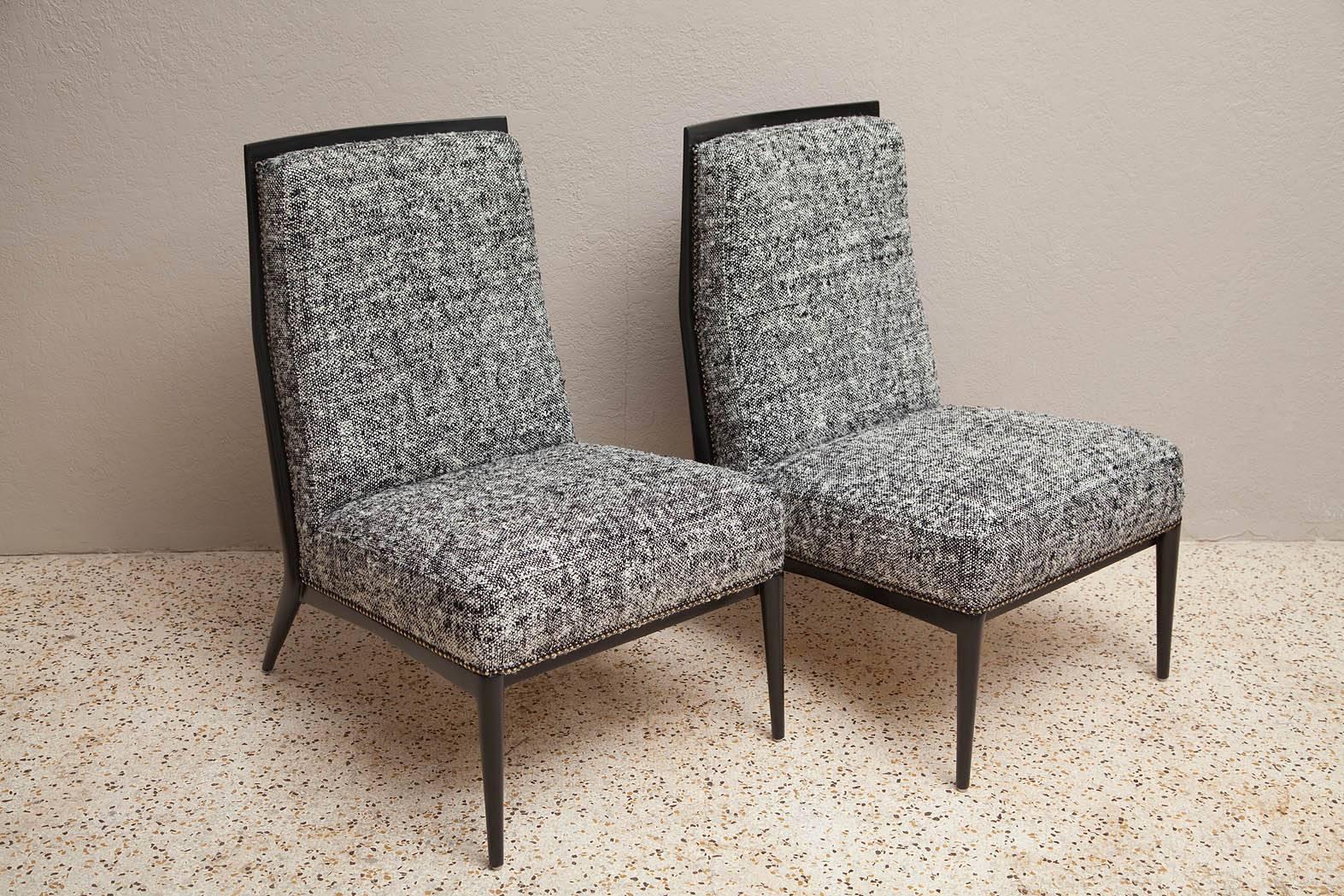 Professionally restored 1950's slipper chairs by Paul McCobb have ebonized walnut frames, upholstered in a thick salt-and-pepper raw silk tweed with nail head trim.