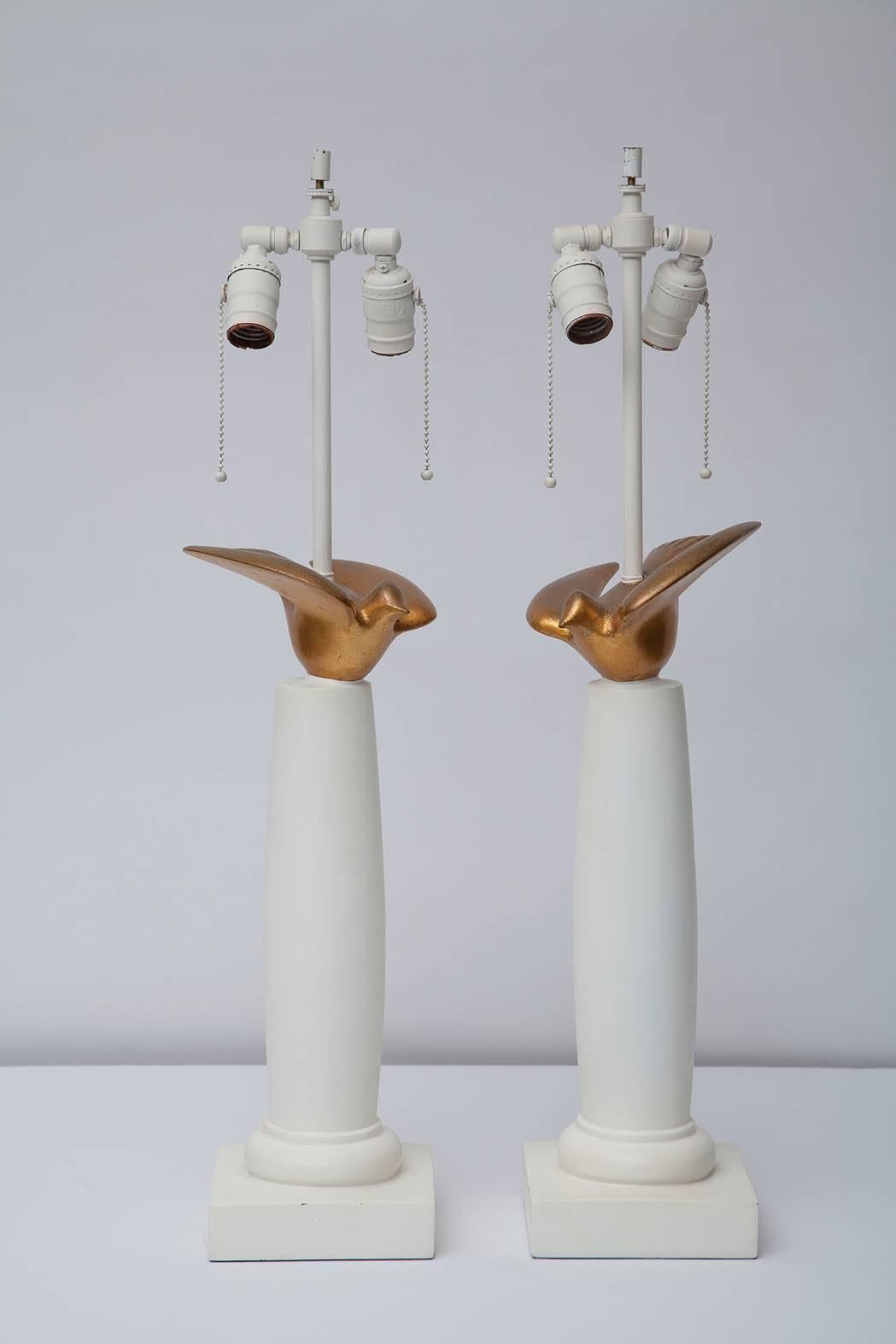 Ein Paar Sirmos-Lampen aus den 70er Jahren in weißem Gips haben dorische Säulen, die von stilisierten Tauben in Blattgold gekrönt werden.
