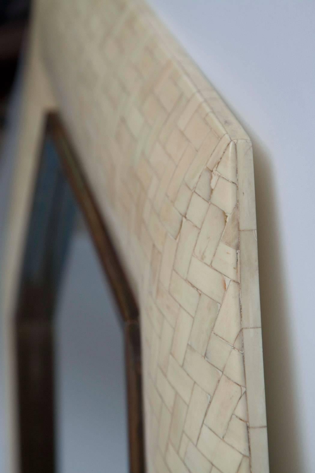 1970s tessellated bone and bronze mirror in the style of Enrique Garcel. Fully restored, herringbone-patterned tile retains the variance of natural bone colors, ranging from creamy off-white to slightly gold to palest grey.