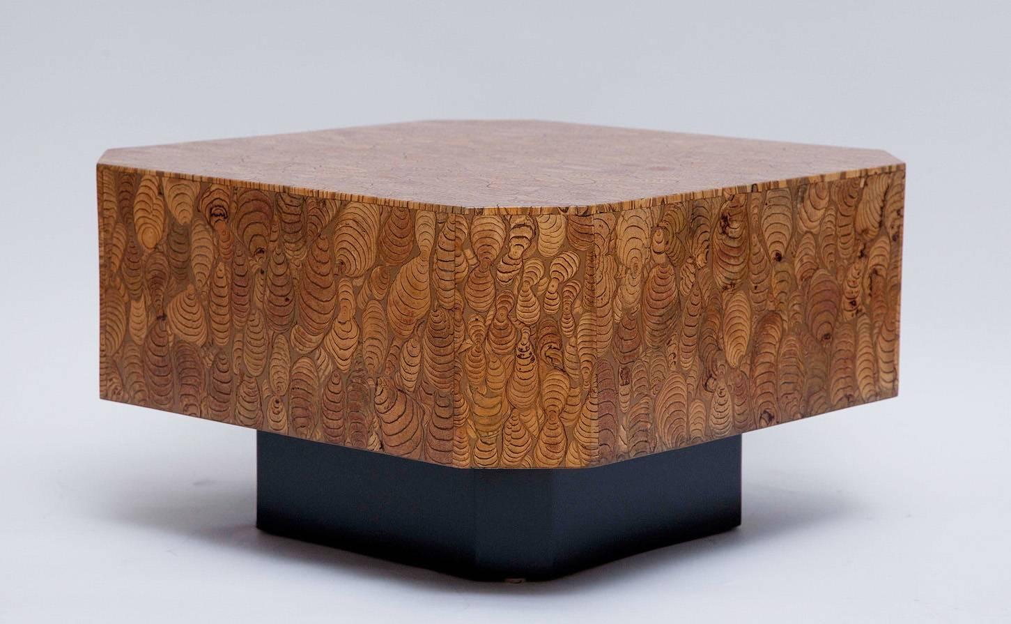 Superbly crafted 1970s side table features resin-coated top and sides, inlaid with dramatically figured exotic wood specimens. Black painted wood base. Excellent professionally restored condition, maker unknown.