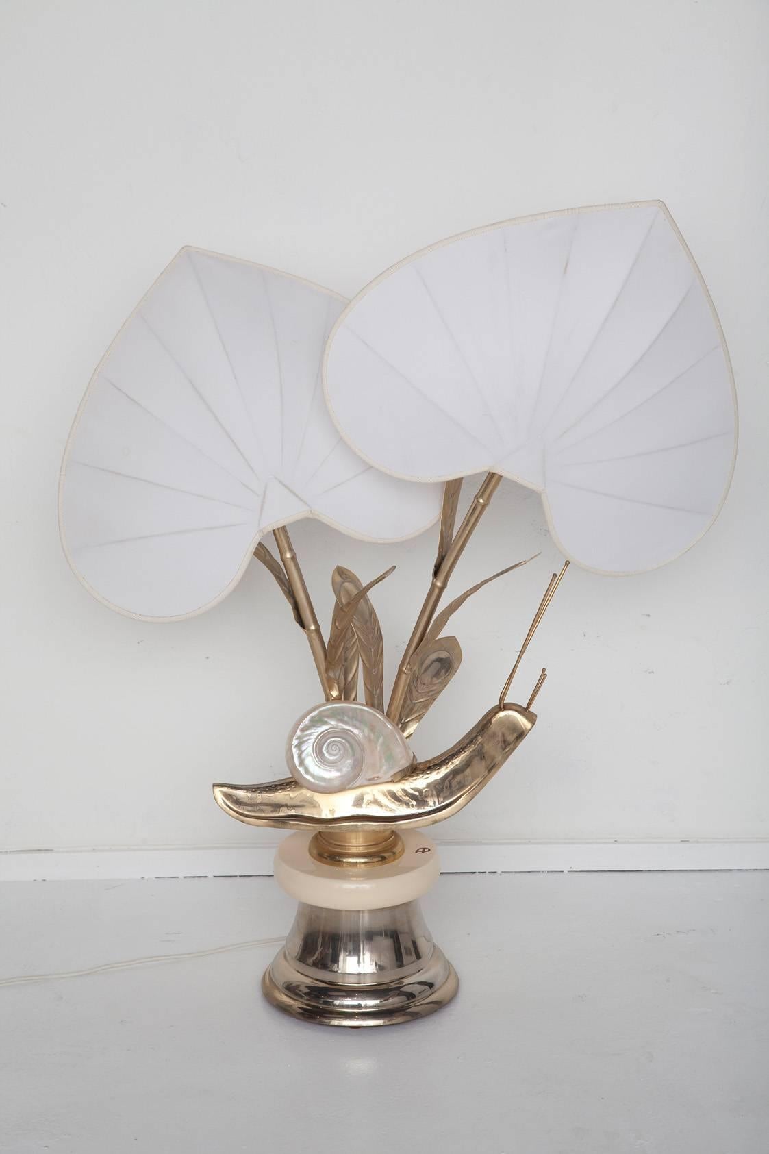Whimsical over-scaled Italian brass snail table lamp by Antonio Pavia, circa 1975,  sports a shimmering mother-of-pearl nautilus shell and original leaf-shaped silk shades. Signed AP on the cream enamel base. U.S. wiring.