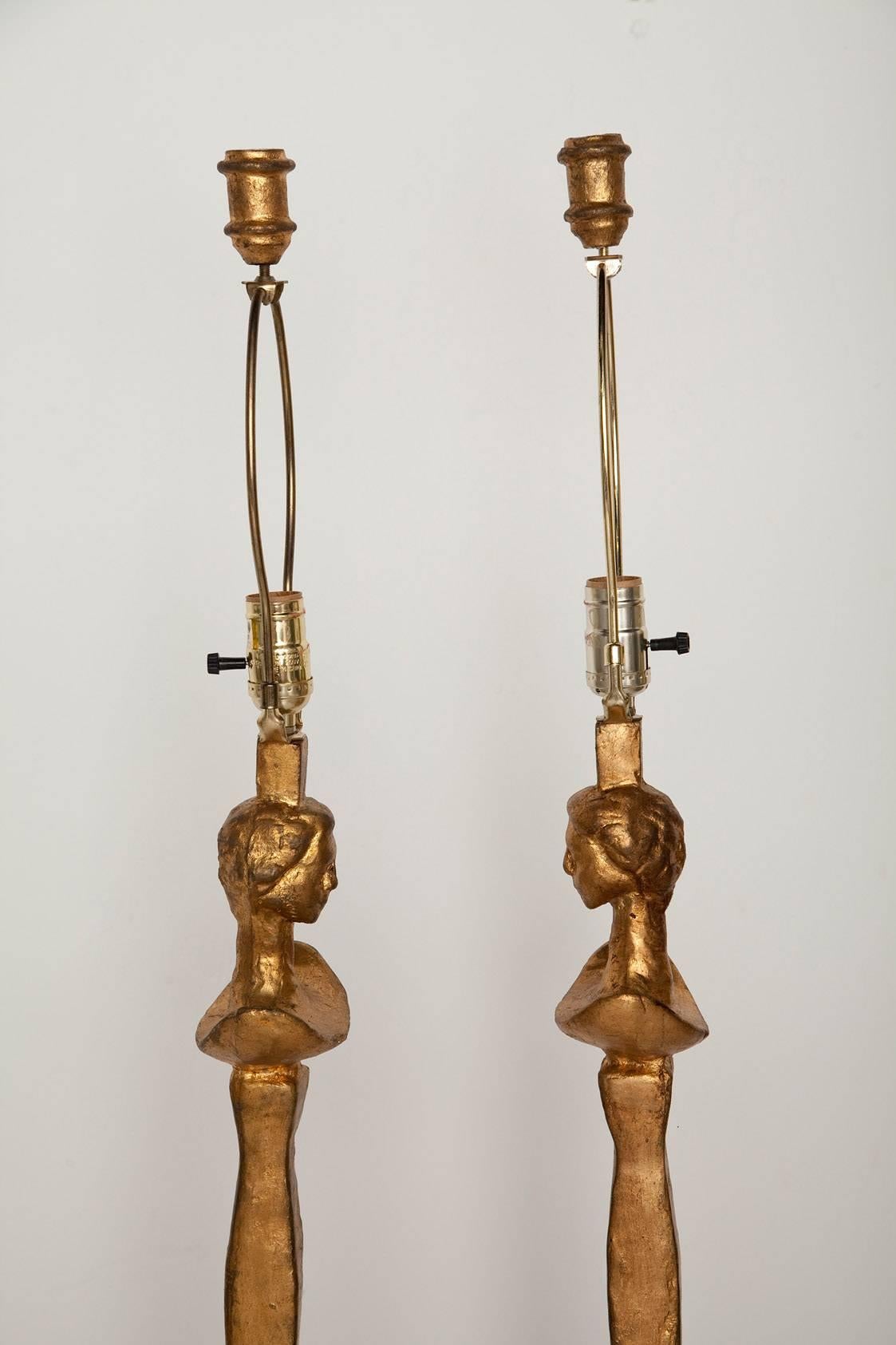 Pair of patinated gold hand-cast metal floor lamps, inspired by Giacometti's iconic Tete de Femme. Height measurement below is to top of finial. Top of socket is 52.5 inches. (Shades are for display only.)