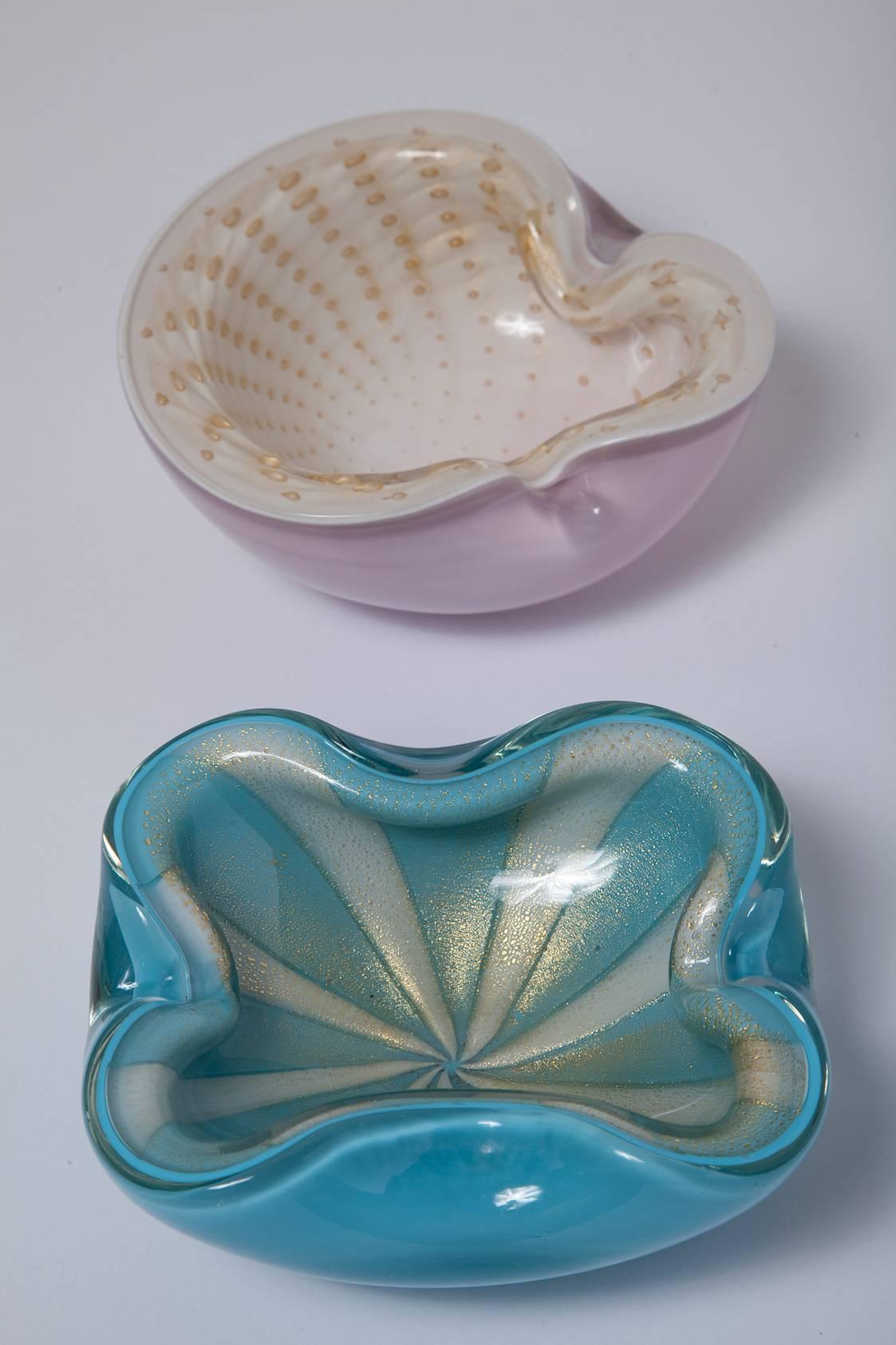 The pink Murano piece is sold. The second Barbini bowl is gold-dusted Murano glass with a blue and white circus tent pattern and measures H 2.25in. x W 6in. x D 5in. We love it as a serving piece for nuts or candies, or as a bedside vide poche.