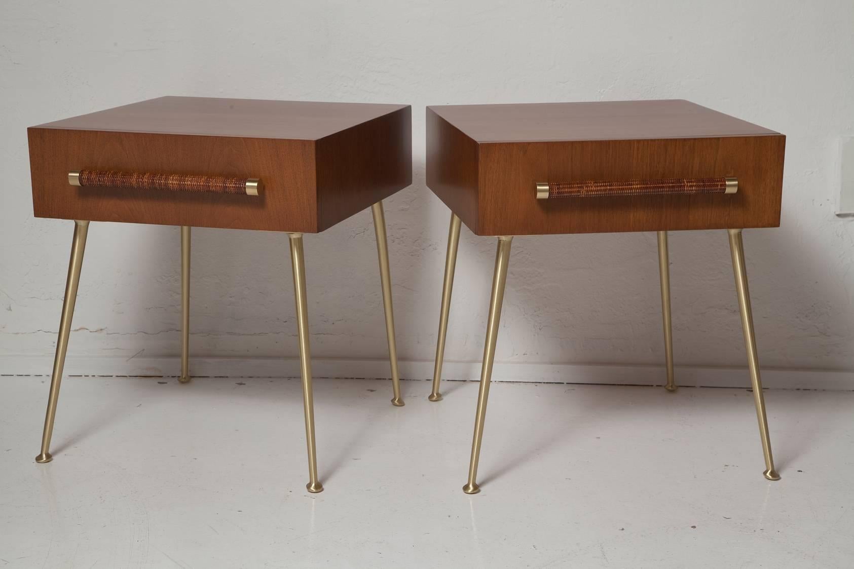 Designed by T.H. Robsjohn-Gibbings for Widdicomb Furniture Company, this rare pair of fully restored 1950s American walnut nightstands have cane wrapped handles and brushed brass legs and fittings. Fabric labels in both. Model no. 4001.