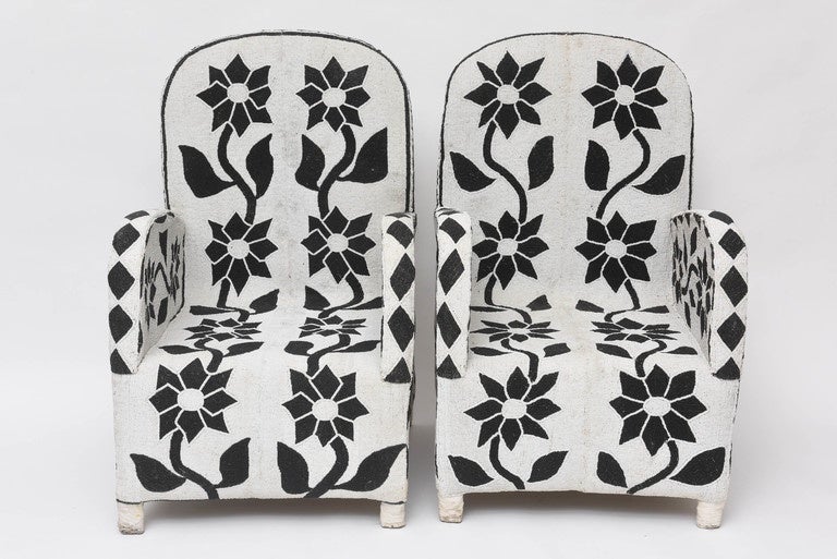 Striking pair of African chairs with a traditional floral pattern, intricately executed in graphic black and white glass beads over a wood and canvas frame.