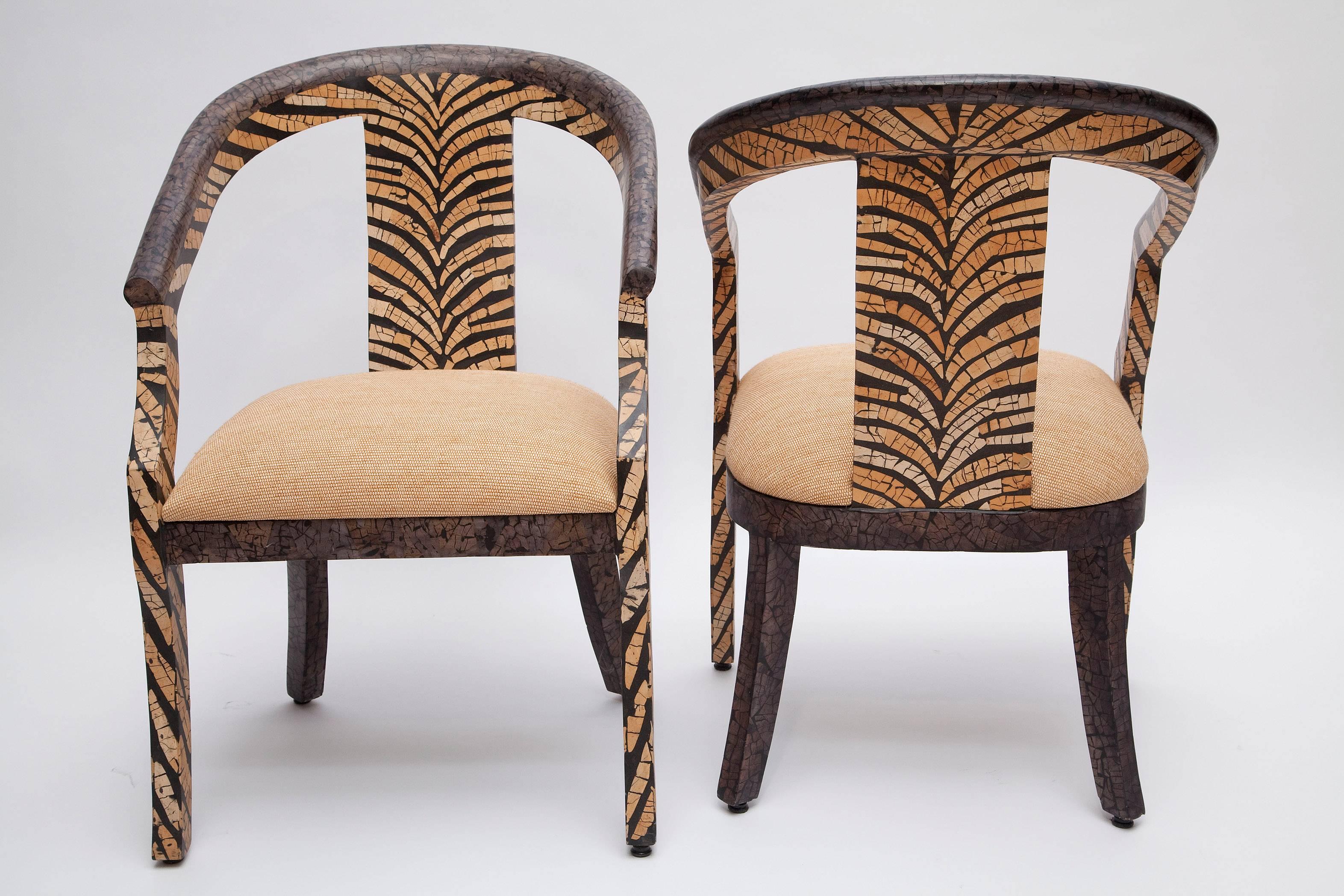 Fun and fierce-some 1970s barrel back armchairs! Natural and blackened inlaid coconut shell set in a fabulous tiger-stripe pattern. Newly upholstered in a natural paper raffia.