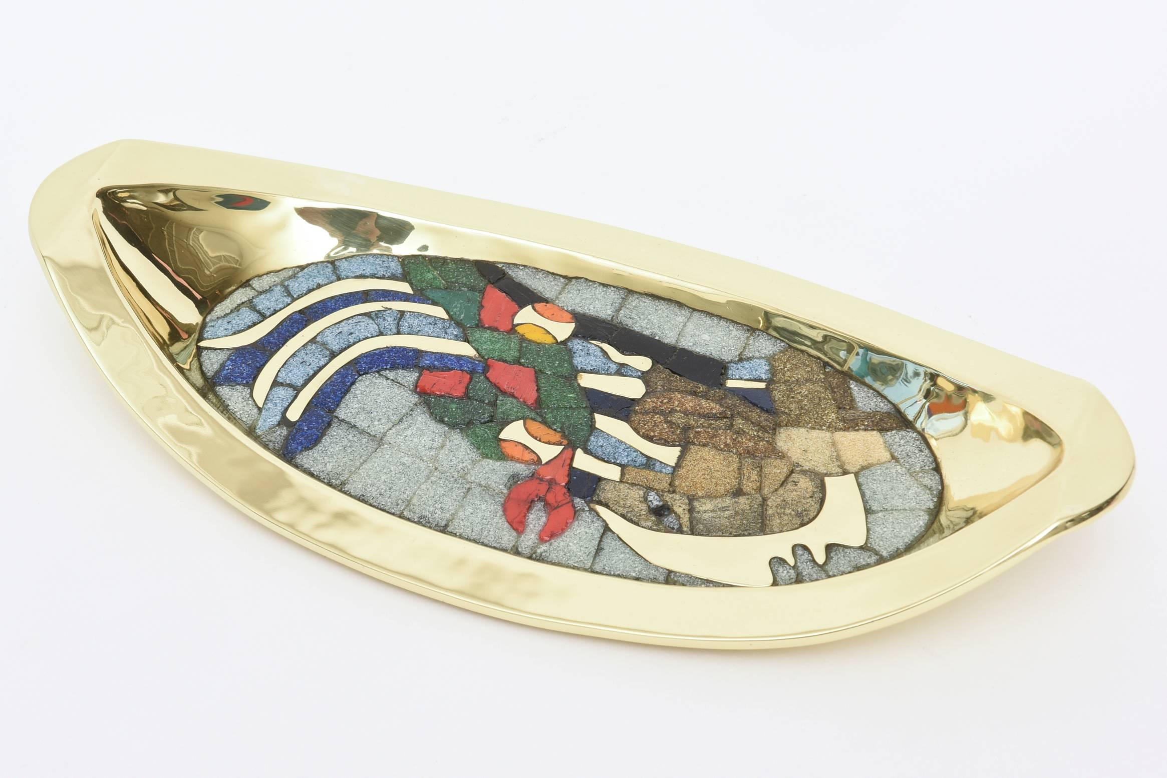 Beautiful array of glass mosaic against the polished brass sculptural bowl/object in this attributed and style of the Mexican metalsmith; Salvador Teran work of art.
The colors that are depicted are royal blue, green, orange, mustard yellow, brown,