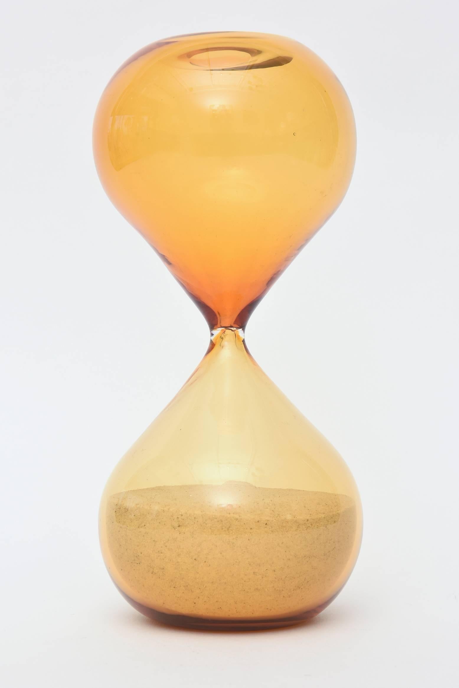This wonderful sand hourglass sculpture is a beautiful color of amber yellow depending on the light.
It has the dimple on the bottom and this is the larger one made from 1952.
It is Venini Murano, Italian.
This is the real deal!