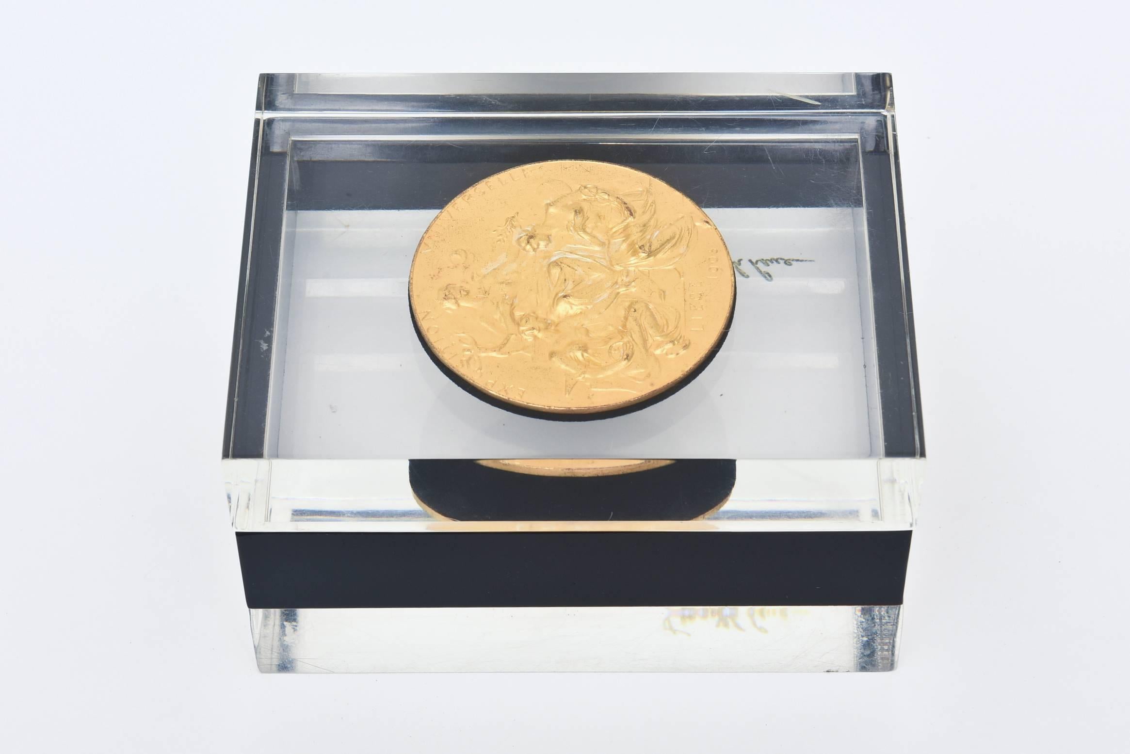 This amazing and stellar lucite and bronze box is two parts.
The clear, black and then clear layers make for a great reflection. The French bronze medallion on the top is old world meets modern. The french intaglio bronze medallion reads