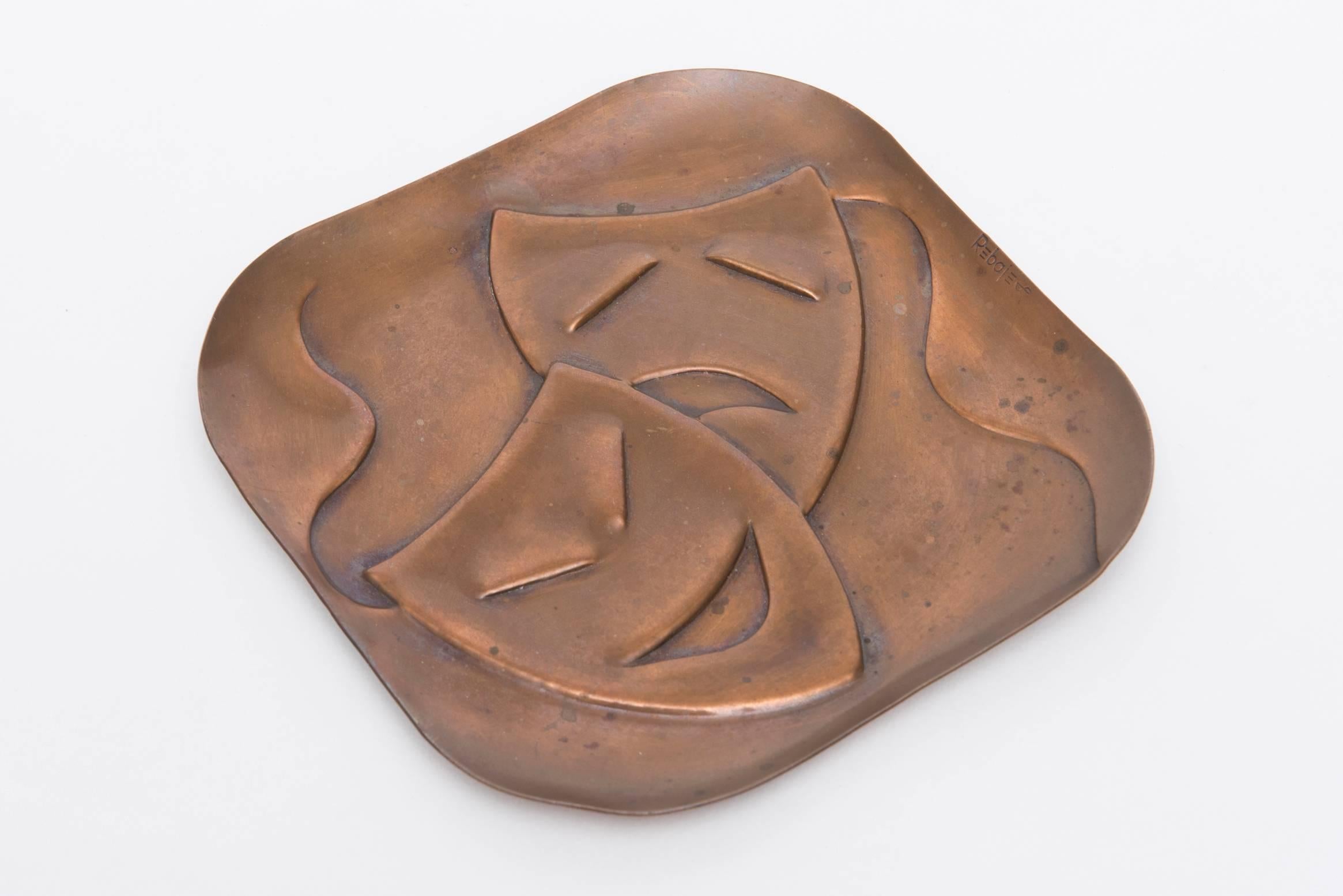 This delightful theatrical signed Rebajes tray/object has a wonderful patina.
The two abstracted masks are comedy and tragedy.
It is vintage and makes a great object.