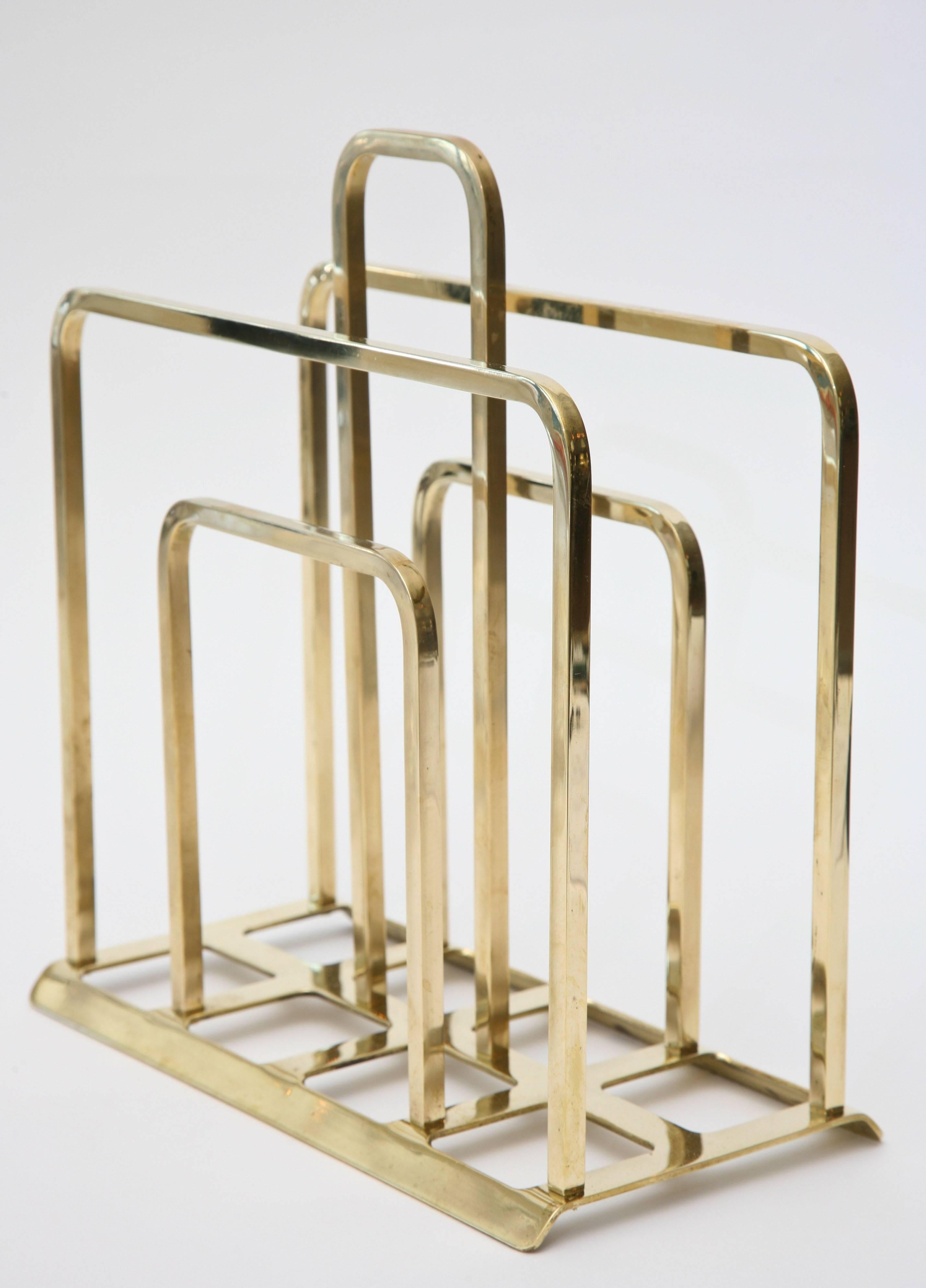 This small grid like solid brass magazine stand/rack can fit anywhere. It is a great size because it is compact. It is Mid-Century, timeless and modernist.
It is more on the lighter side than the heavy side. Very well made from the time.

