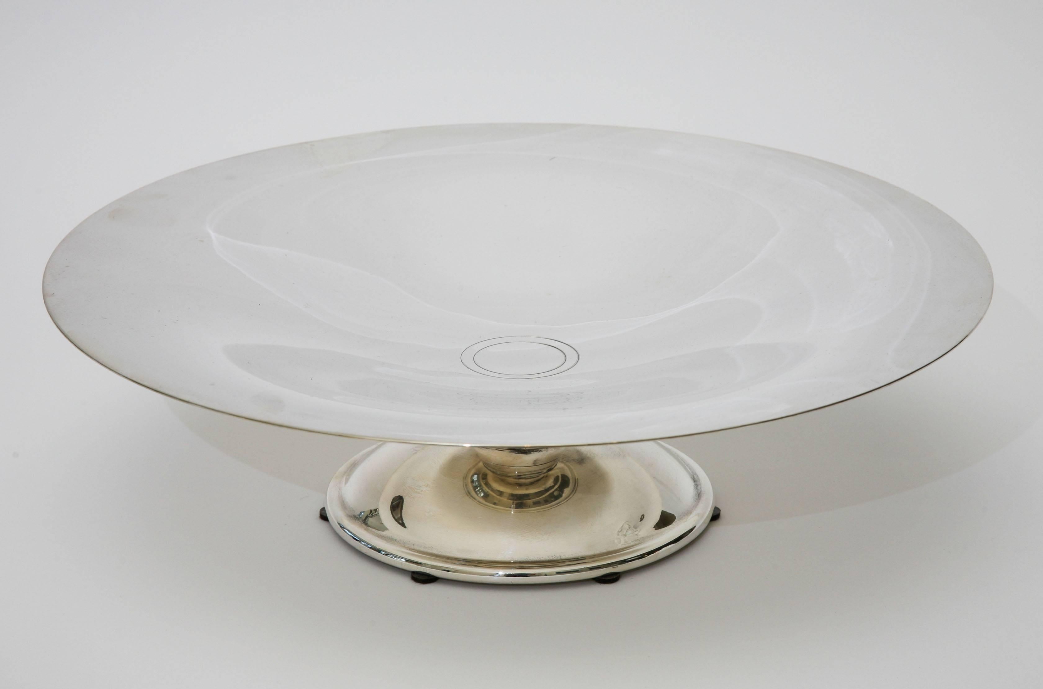 This timeless and classic French hallmarked polished silver plate pedestal bowl is a great centerpiece and or serving bowl. There are two concentric circles in the center.
The brown half circles at the bottom are felt pads. It is hallmarked