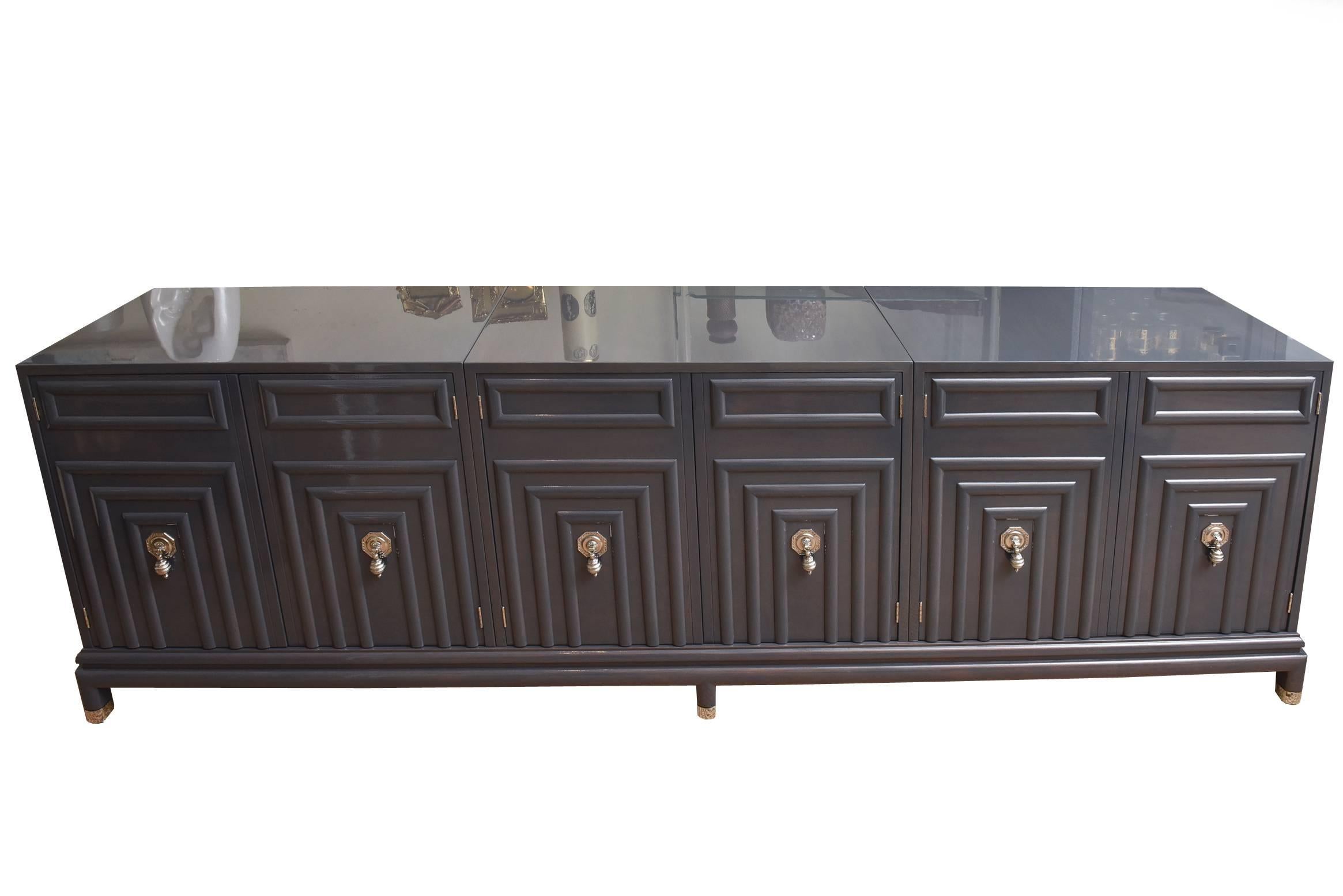This fully restored and absolutely stunning cabinet/buffet by Renzo Rutili for Johnson Furniture Company is so modern. It is three parts/three cabinets on a base.
The original fabulous hardware and hinges has all been nickeled silver.
The carved