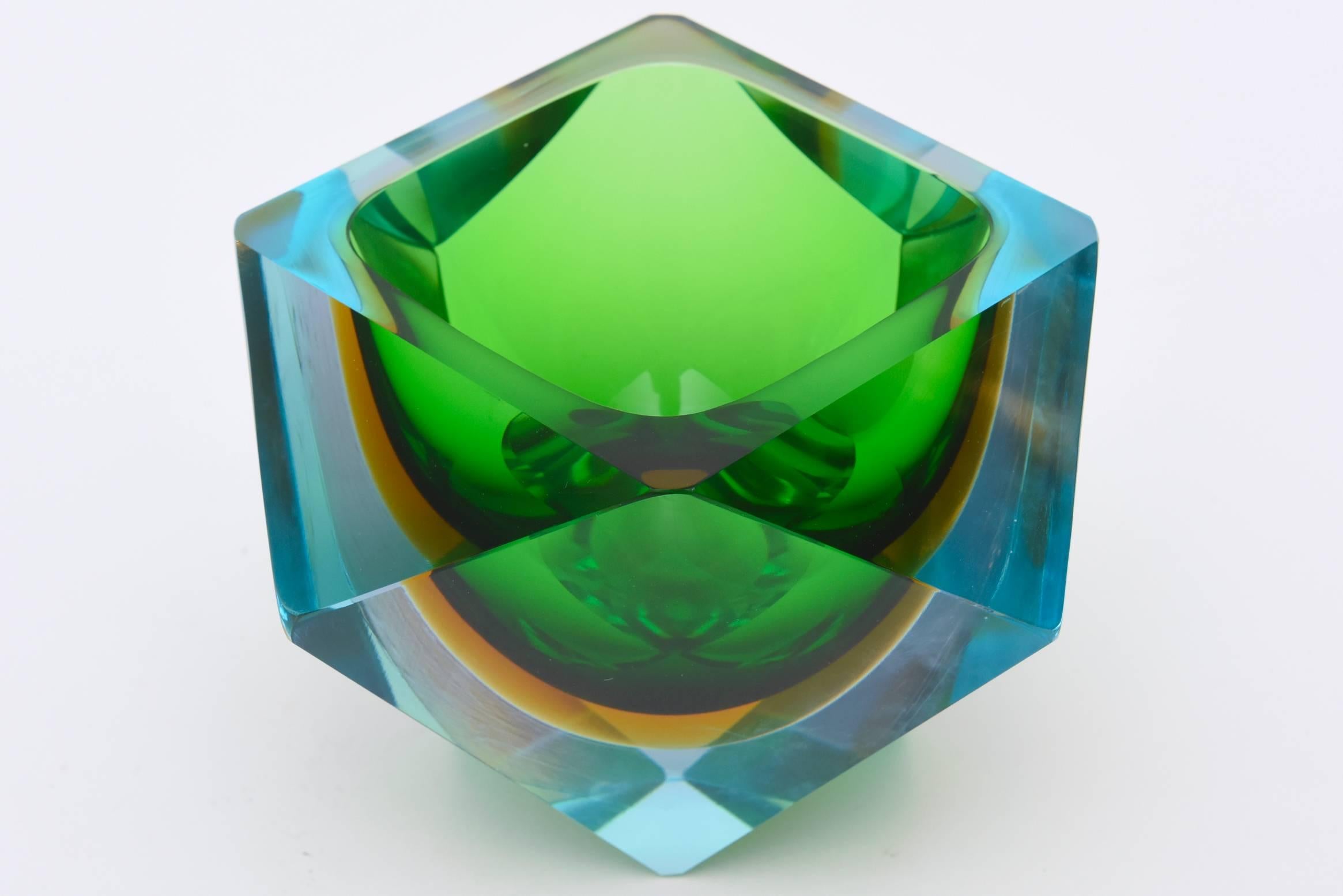 The stunning colors of the turquoise to sapphire blue to emerald green to the amber all in Sommerso faceted glass form add a sculptural presence to this most beautiful Italian Murano bowl that is in an inverted triangle form.
It is rich in color,