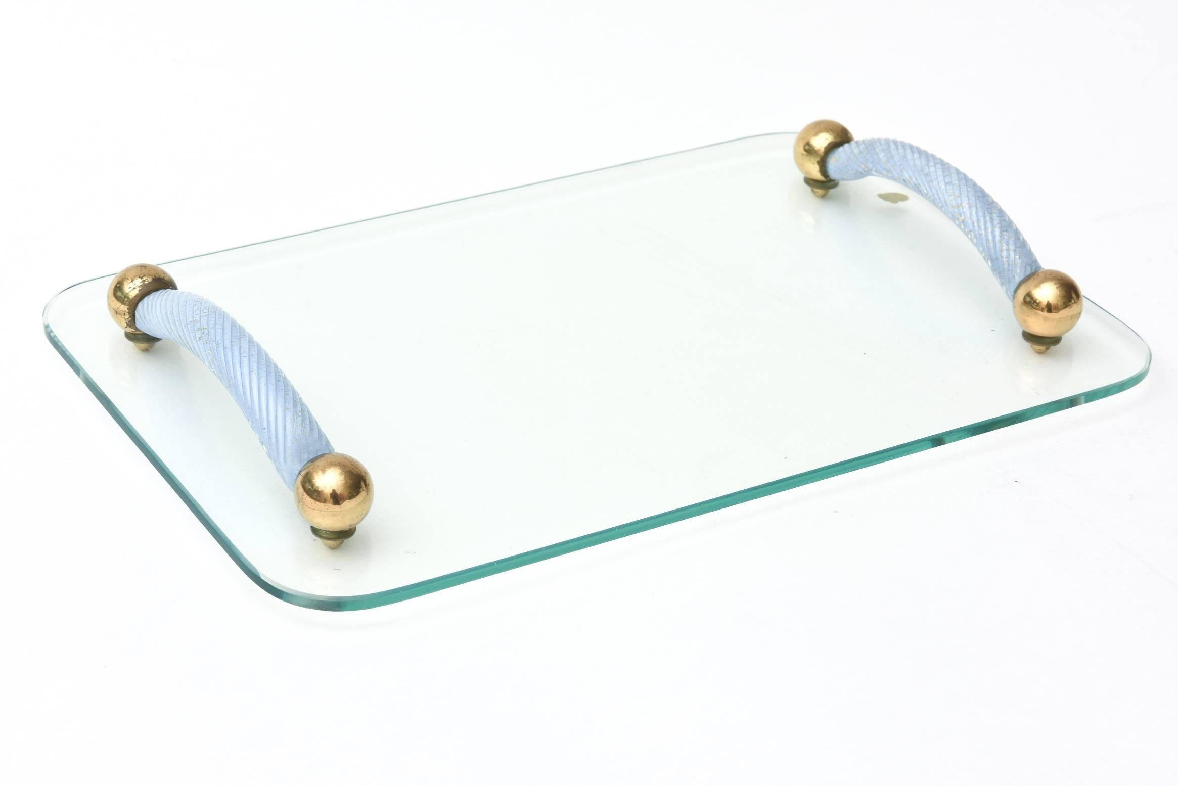 This lovely and versatile Italian Murano glass tray attributed to Seguso has the original label; albeit only half intact on the back. The beautiful gold aventurine is encased in the periwinkle blue raised and spun twisted glass handles. The interior