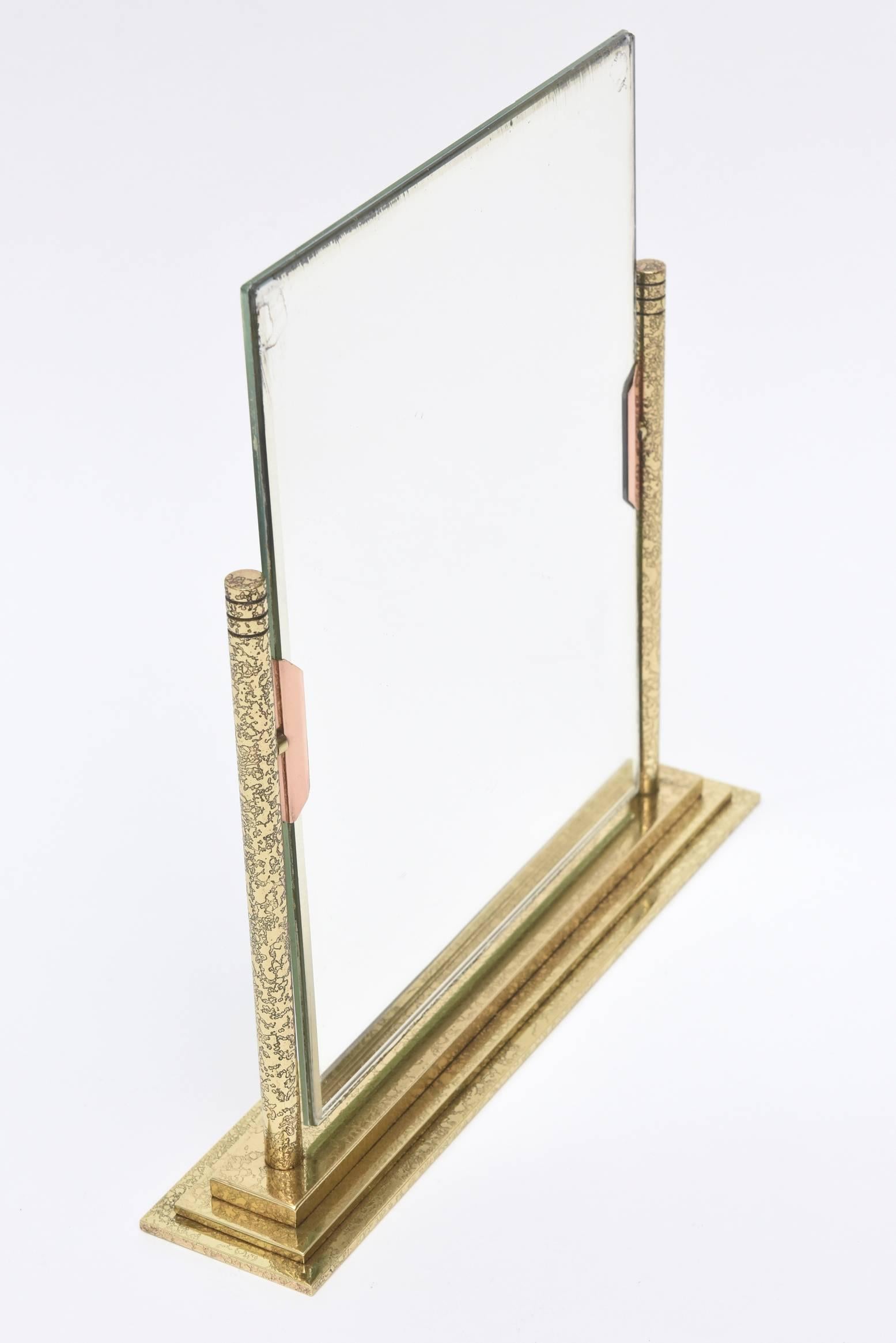 The hand tooled brass on the bottom and frame is a tight beautiful design. The rose colored tabs on the front are bronze. It is a both a picture frame on one side and a mirror on the other. The metal has all been professionally polished.
Please