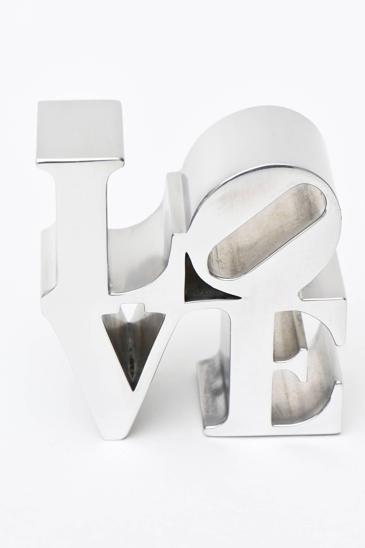 This original paperweight love sculpture that was done in the 1970s by Robert Indiana was sold at that time at MOMA. It is polished aluminium.

It was a small rendition of Robert Indiana's original love painting that put him on the map
as a