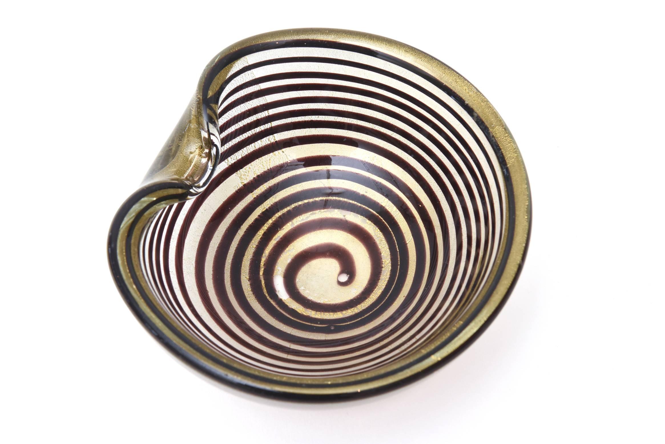 This stunning vintage Italian Murano vintage Seguso optical designed glass bowl has the spiral technique of layered concentric circles filled with gold aventurine. It is of the technique of Zebratti. It is eggplant to aubergine brown. This is also a