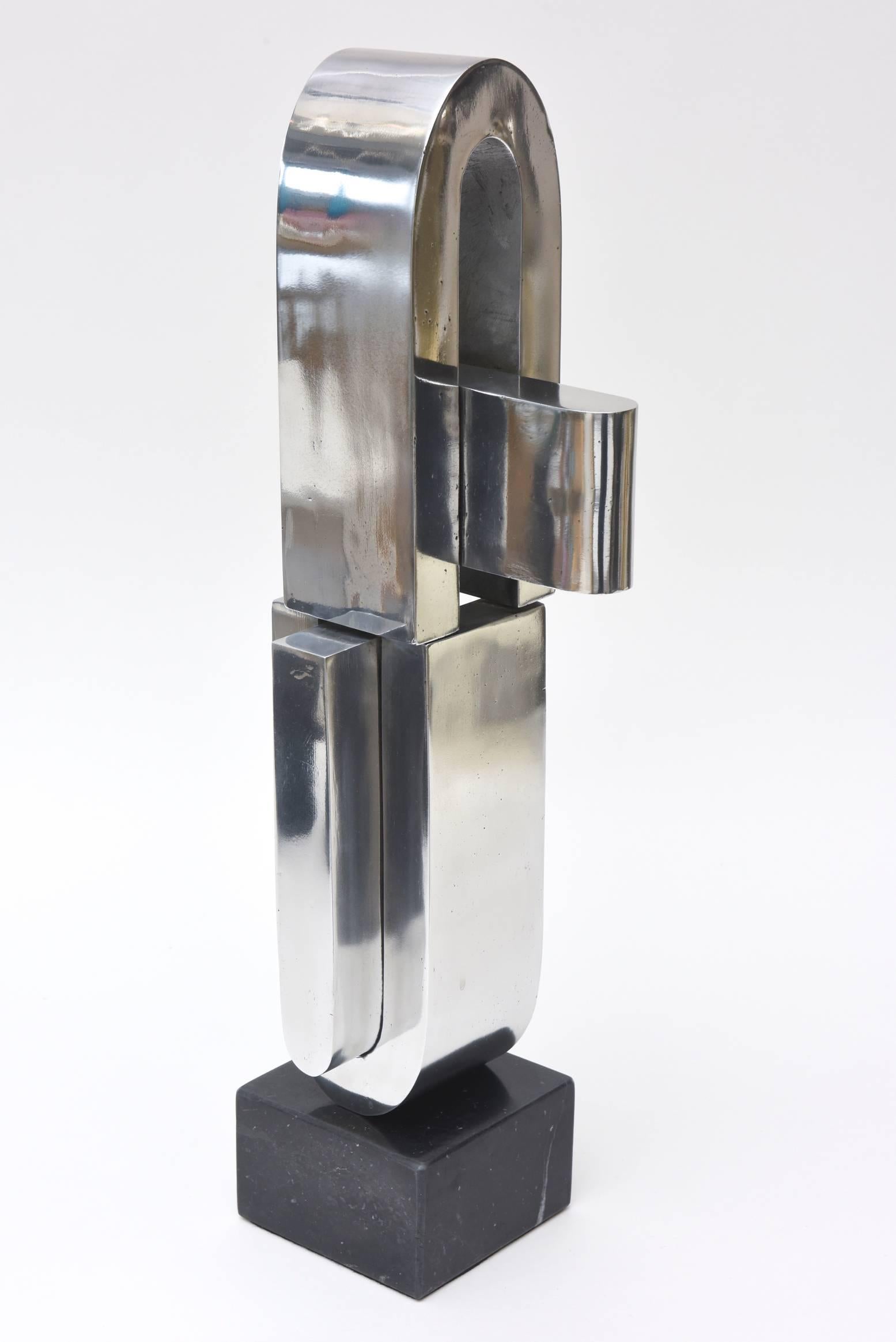 Diese fabelhafte doppelte U-förmige abstrakte Skulptur im Vintage-Stil der bekannten Künstlerin Mary Preminger ist sehr modernistisch. Er ist verchromt und steht auf einem Original-Sockel aus schwarzem Marmor. Sie wurde 1968 ausgeführt. Es ist zwar