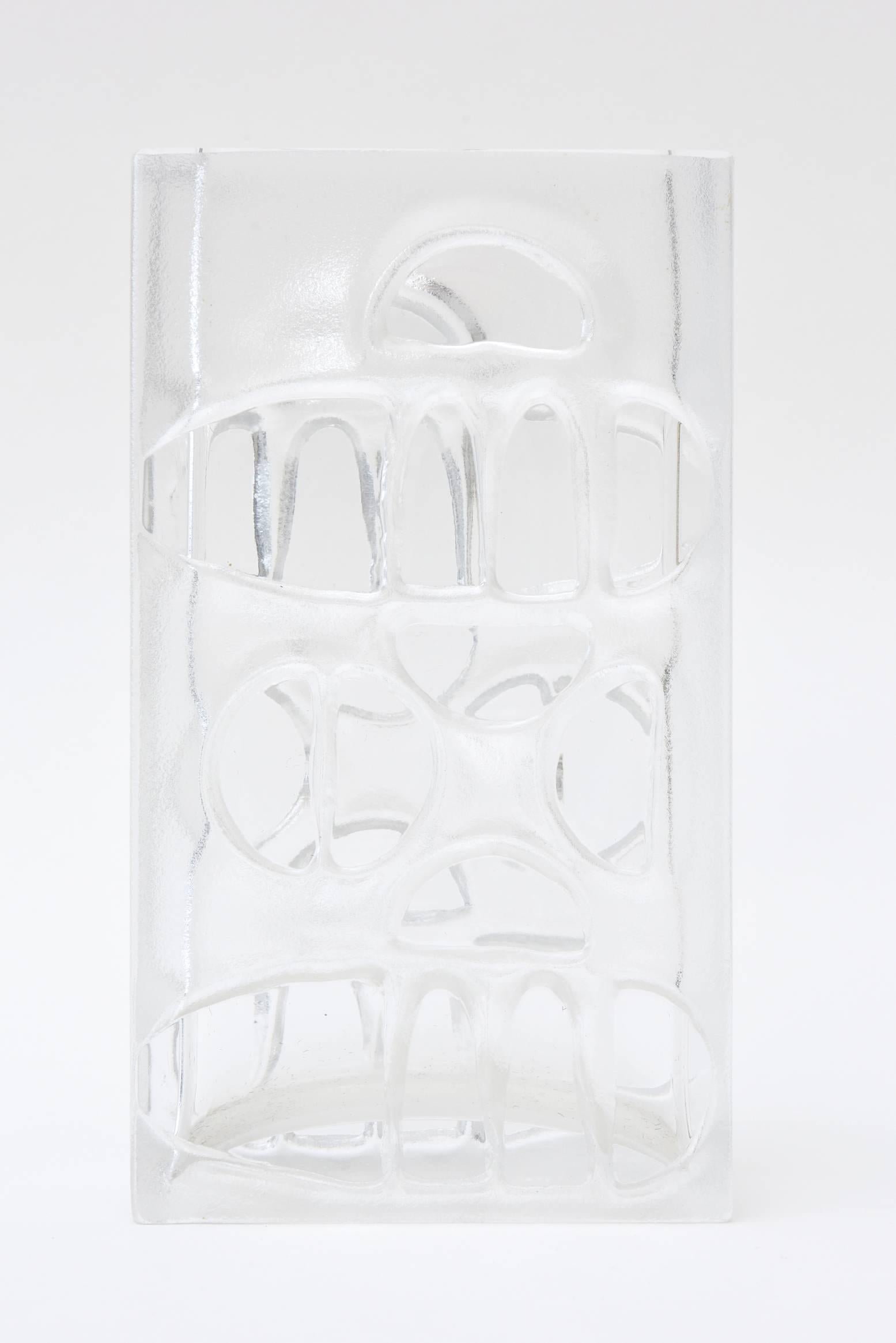 This gorgeous vase that has modernist incised cutout forms is a combination of clear and frosted glass. It has an insignia on the bottom which is the hallmark but after much research we cannot come up with it's maker. This is a beauty and a forever