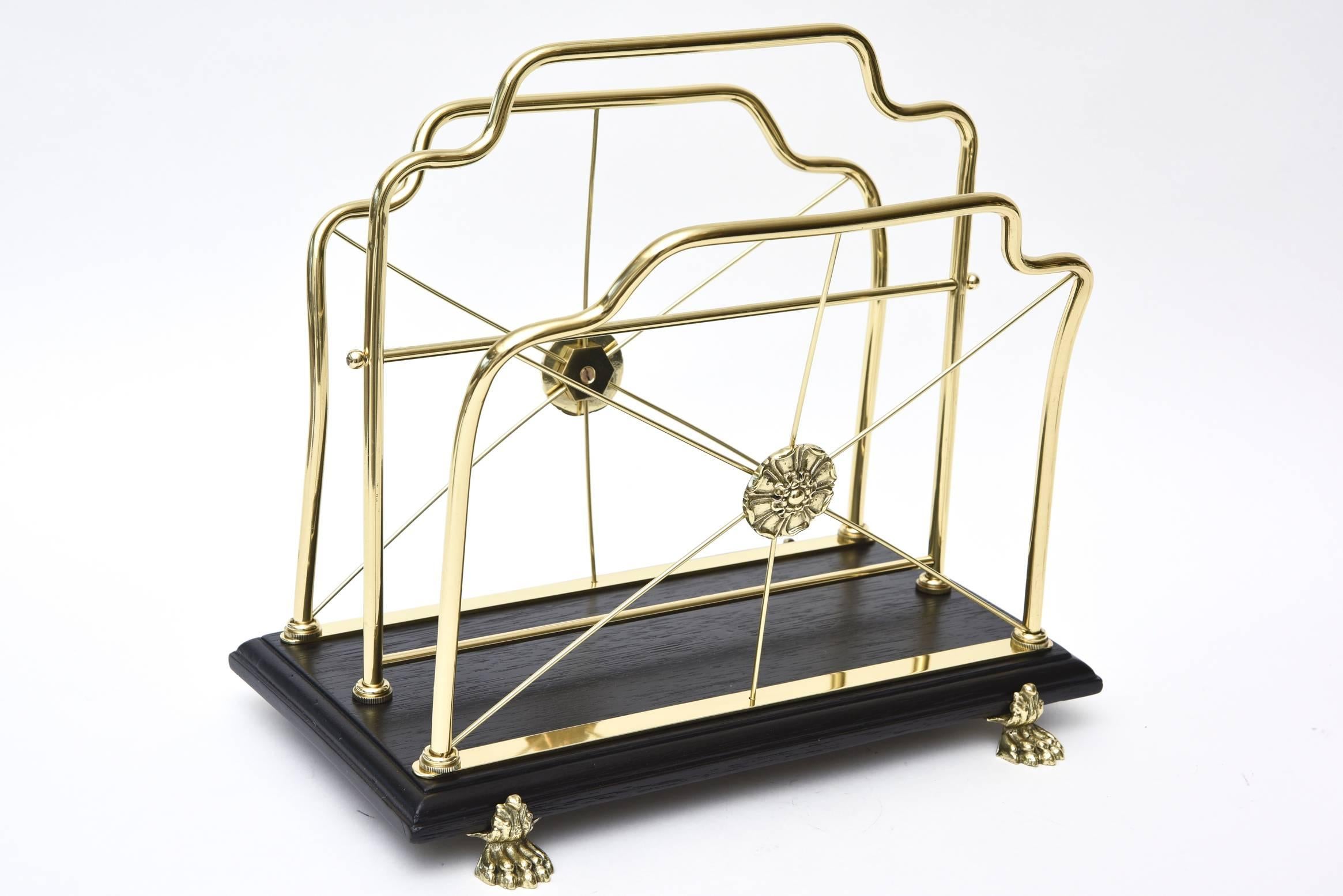 This ultra chic and MaisonJansen style Mid-Century magazine rack has gorgeous claw feet with two compartments for magazines. The two medallions add a French twist. It is a perfect size and the wood has been newly restored with black ebony. The solid