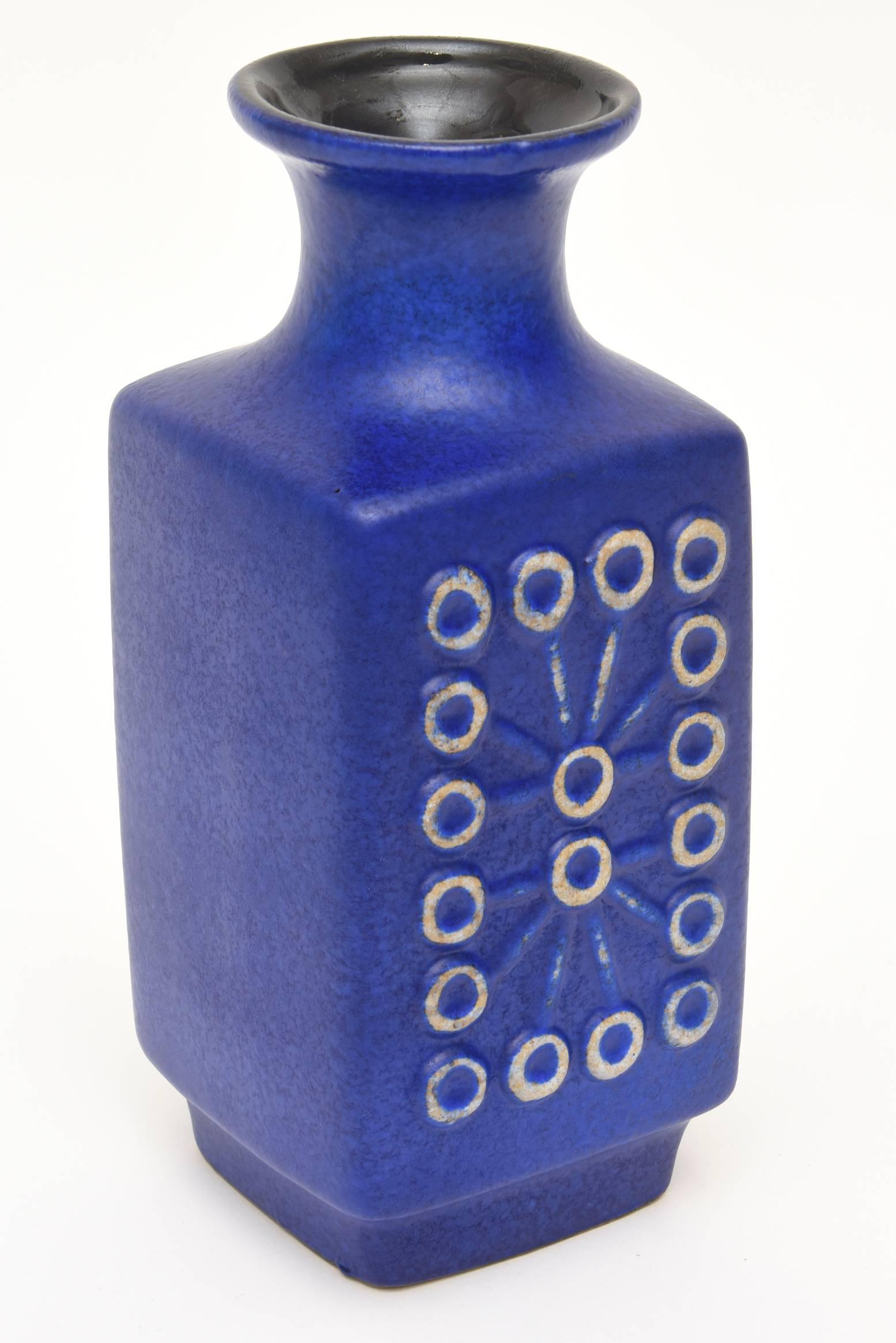 The vibrant color of this deep rich unpredictable cobalt blue vintage German Mid-Century Modern ceramic glazed vase, vessel or object has great geometric design on the front and back of circles and connecting lines. It is fabulous! It has a black