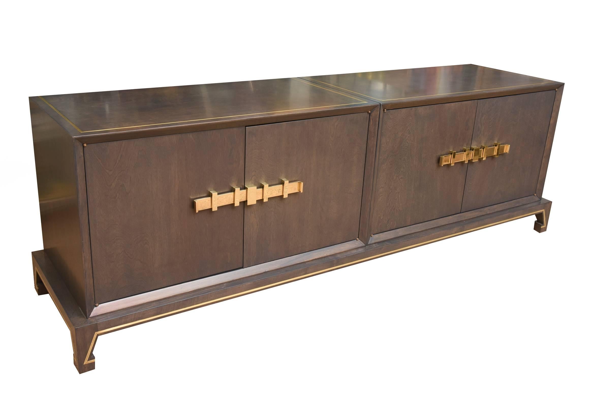 This magnificent and fully restored original vintage Tommi Parzinger Mid-Century Modern low cabinet is sculptural with its monumental polished solid brass hardware that opens the cabinet doors on both sides. It has brass inlay on the top and bottom