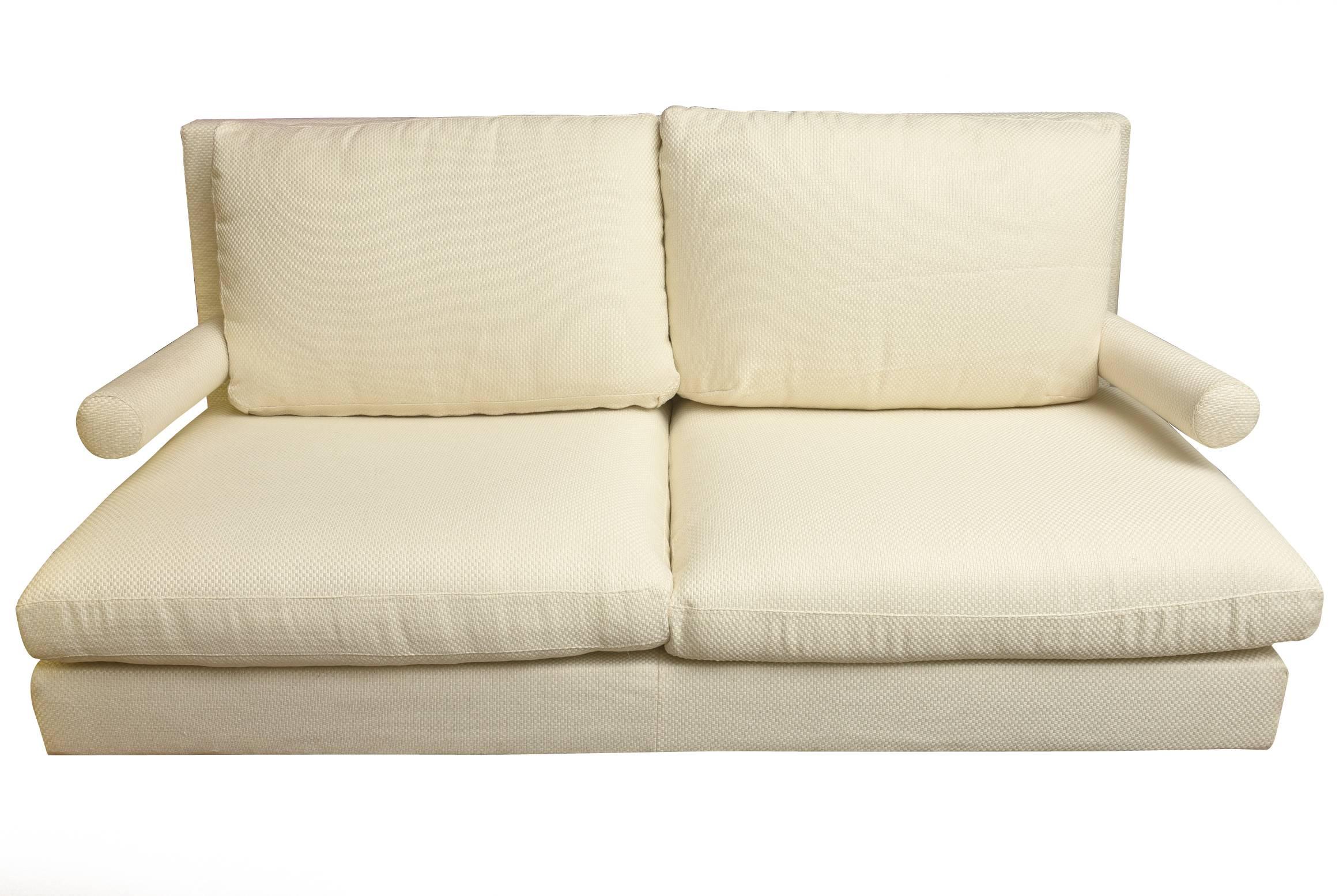 This newly upholstered Italian B&B sofa and or loveseat is from the 1980s. It is in an off-white textural checkerboard upholstery fabric. The sculptural arms add a dimension. It has black metal wheels on the front. It has substantial weight and is