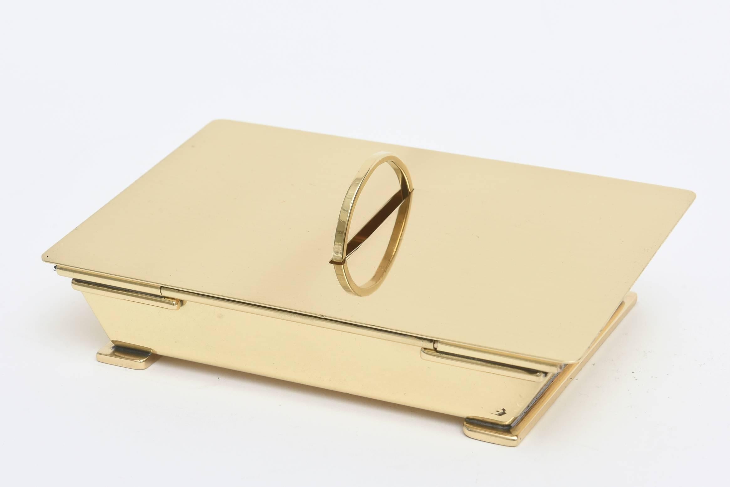 This wonderful brass box is so modernist and Mid-Century. It glistens with
sculptural form.
There is a half circle with an opening when you lift the top part of the hinged box up it now becomes a full circle on the inside with a dissecting brass